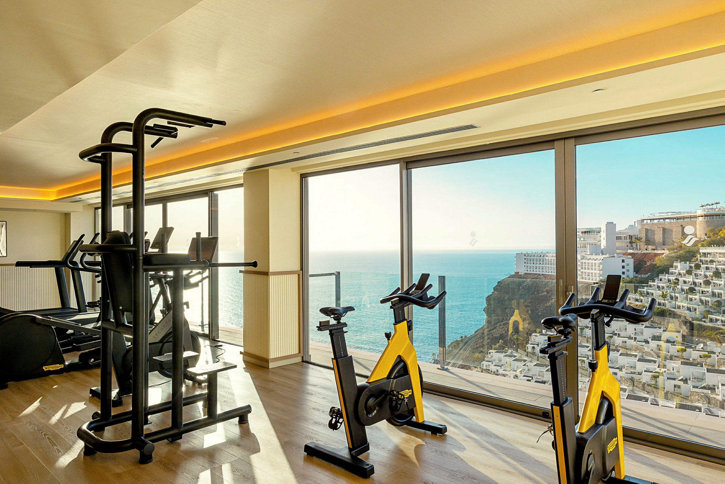Gym med träningscyklar och utsikt över havet. (AI-genererad text)