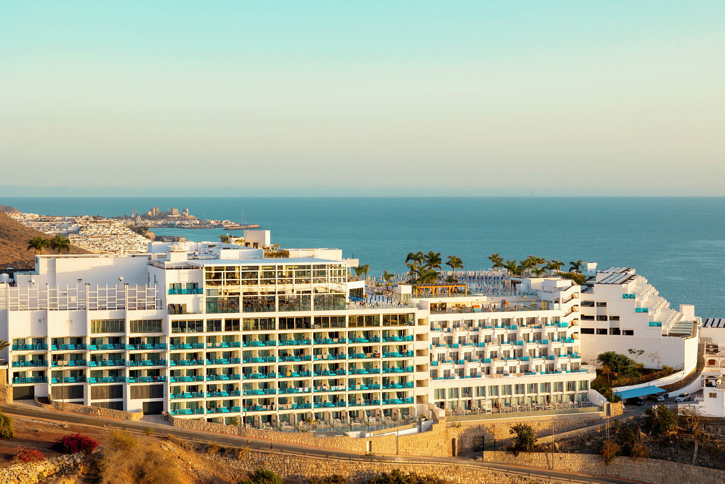 Hotellbyggnad med utsikt över havet och omgivande landskap. (AI-genererad text)