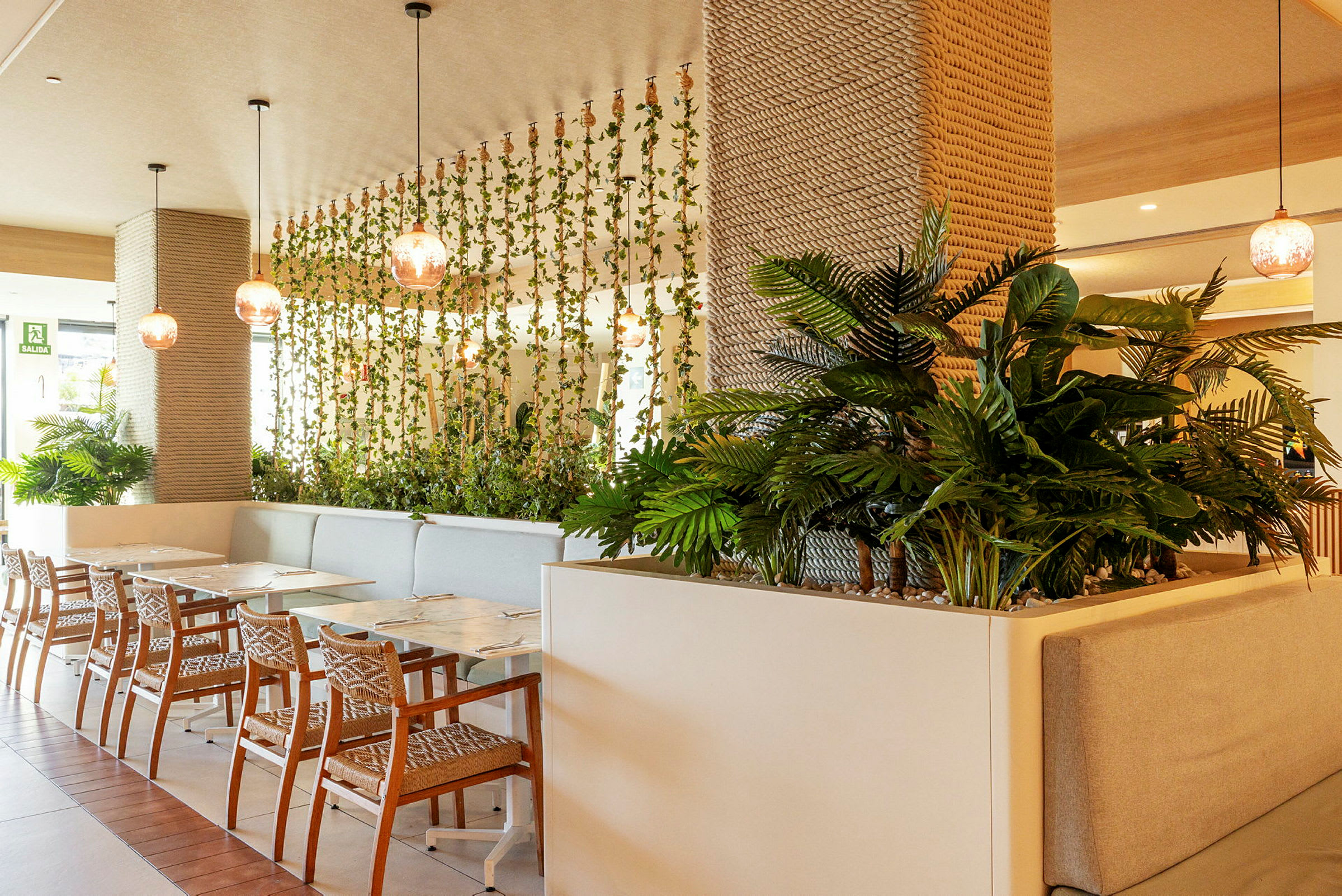 Interiör av en restaurang med väggdekorationer av växter och moderna möbler. (AI-genererad text)