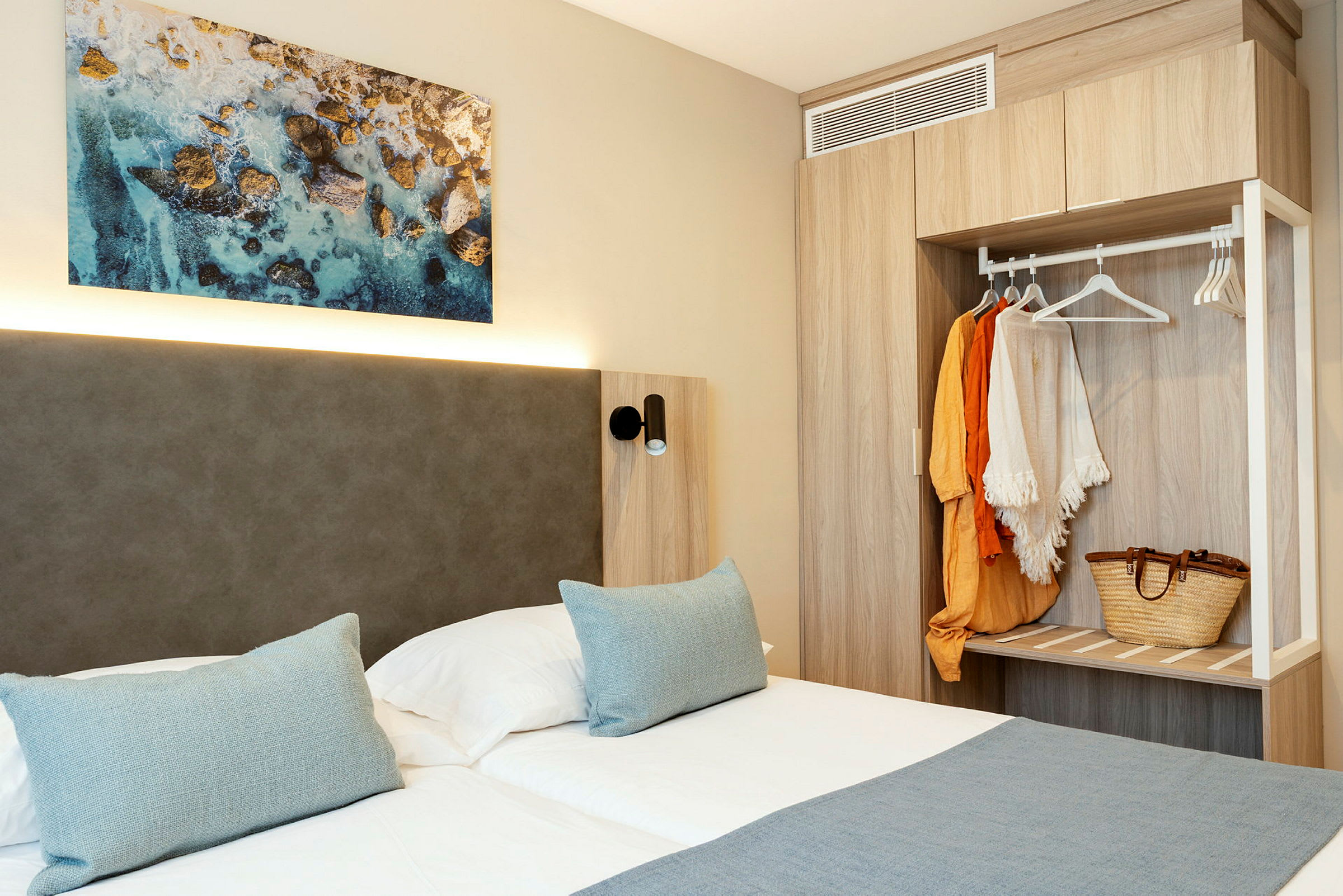 Bild på ett hotellrum med dubbelsäng, väggkonst och garderob. (AI-genererad text)