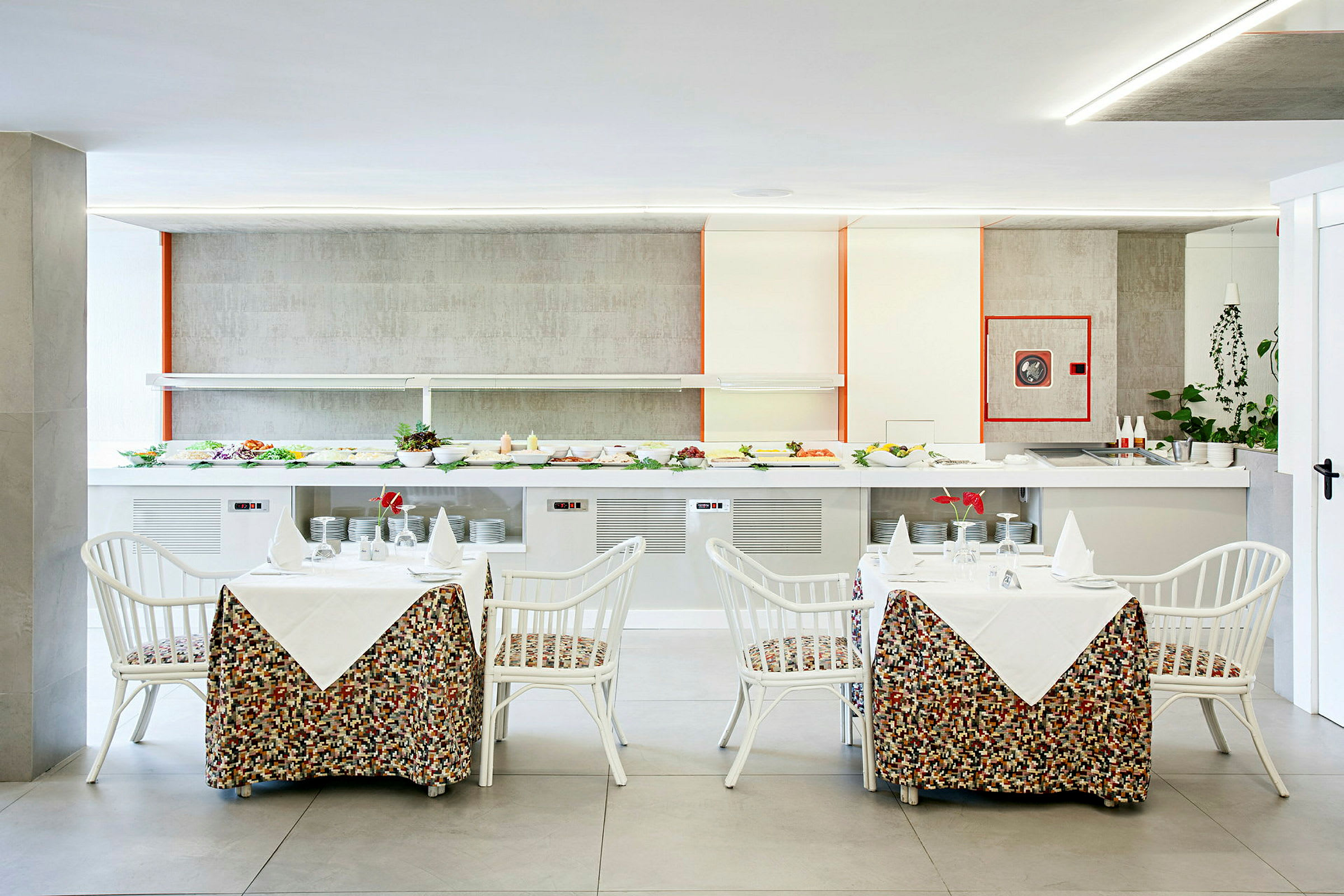 Restaurang med dukade bord framför en salladsbuffé. (AI-genererad text)
