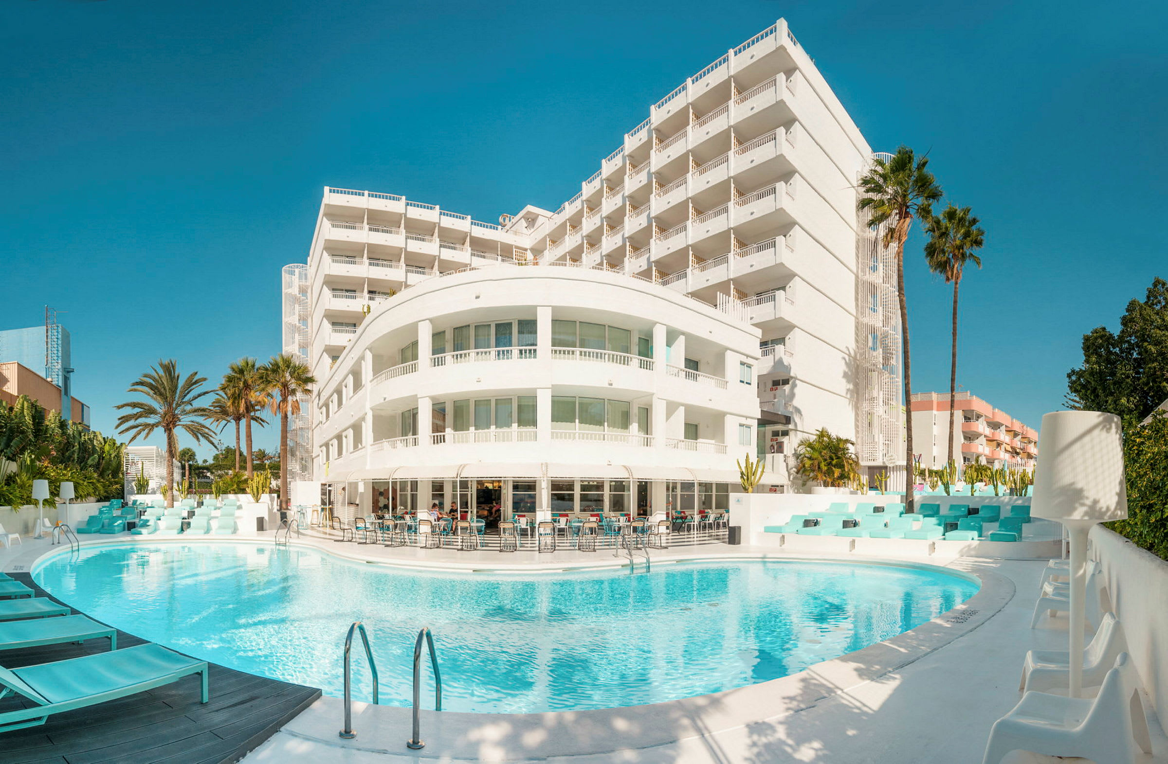 En hotellbyggnad med balkonger och en utomhuspool. (AI-genererad text)
