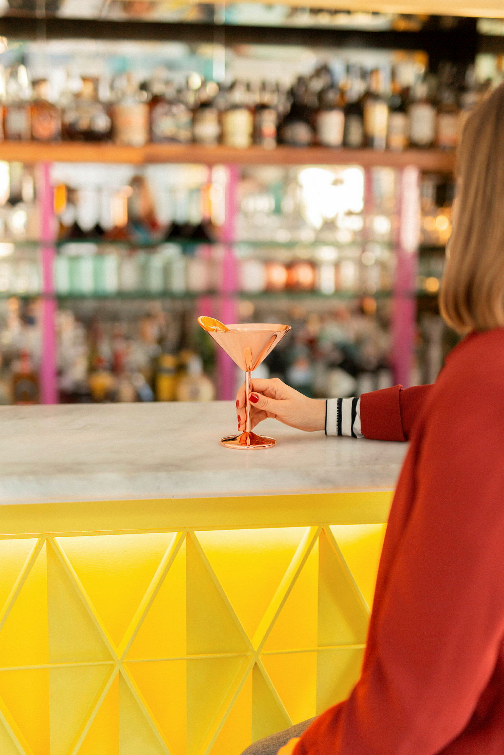 En person håller glaset på en bar. (AI-genererad text)