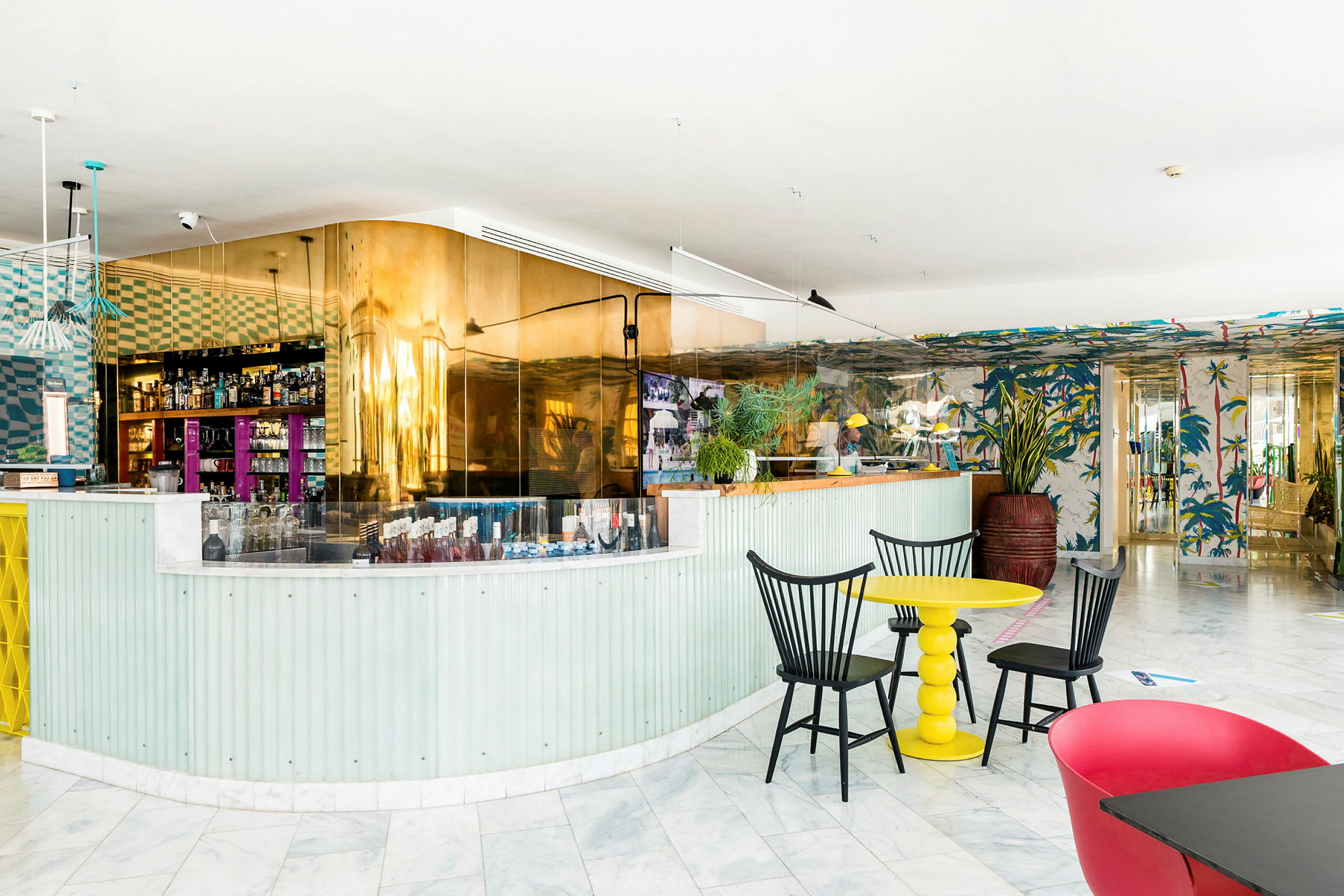 En interiör av en modern bar- och caféområde med färgglada möbler och dekor. (AI-genererad text)
