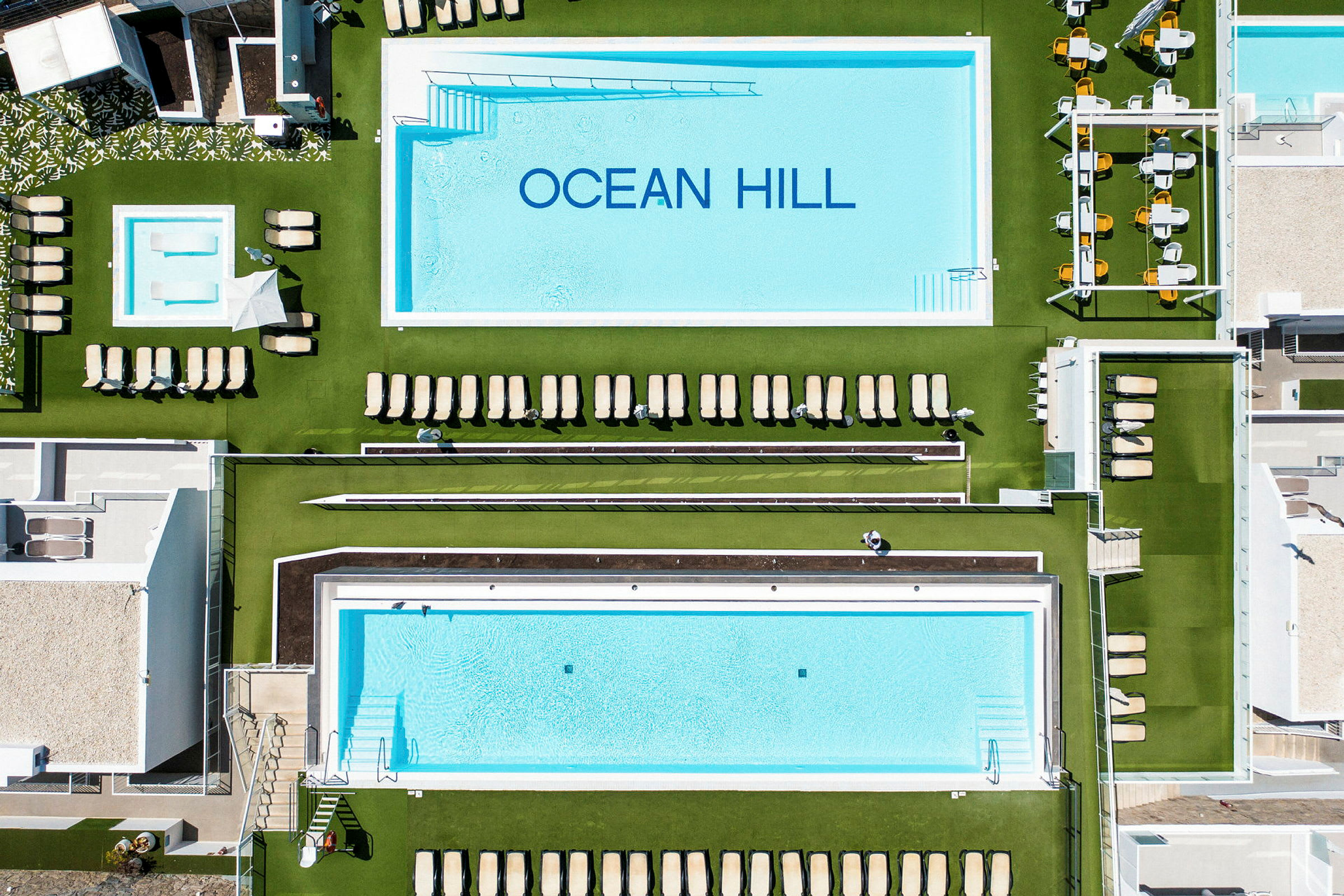 Flygvy över poolområdet vid Ocean Hill hotell. (AI-genererad text)