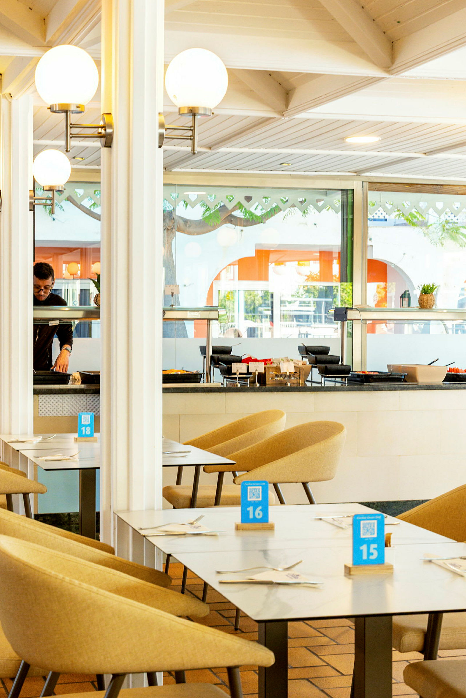 Interiör av en restaurang med bord och stolar, dekorerad med ljusa färger. (AI-genererad text)