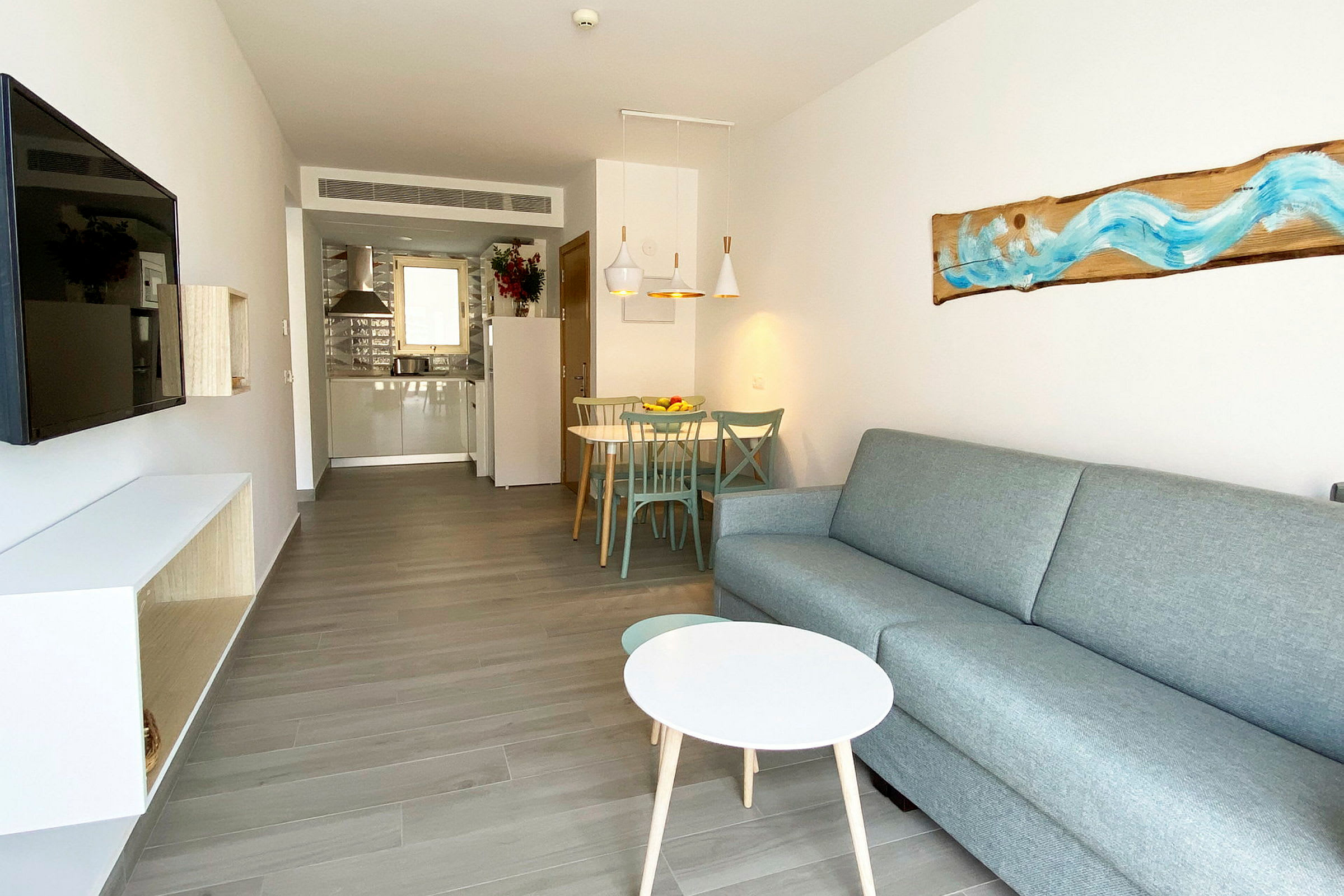 Bild av ett modernt hotellrum med soffa, soffbord, TV och matplats. (AI-genererad text)