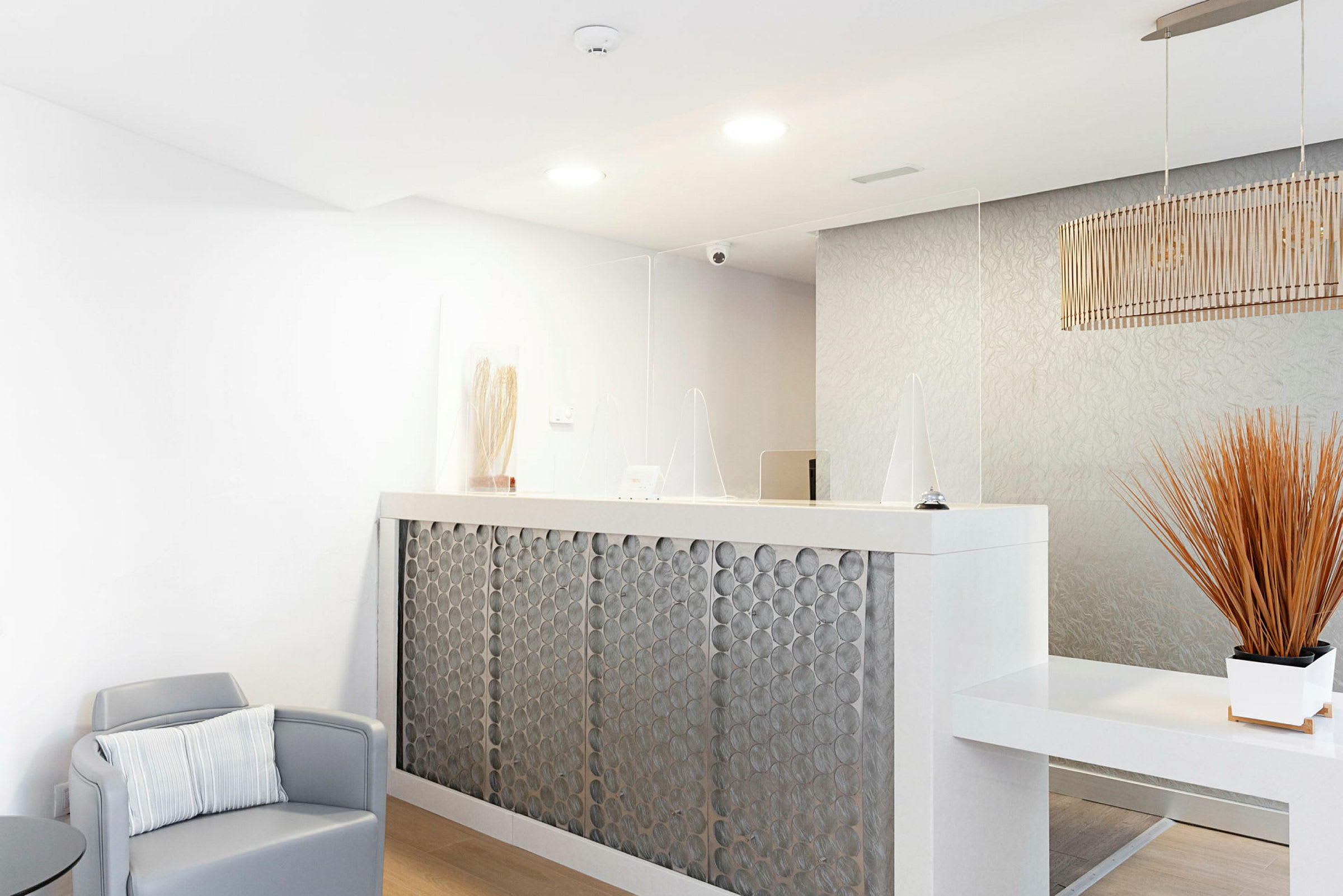 Reception med skrivbord och dekoration, bland annat en stol och en lampa. (AI-genererad text)
