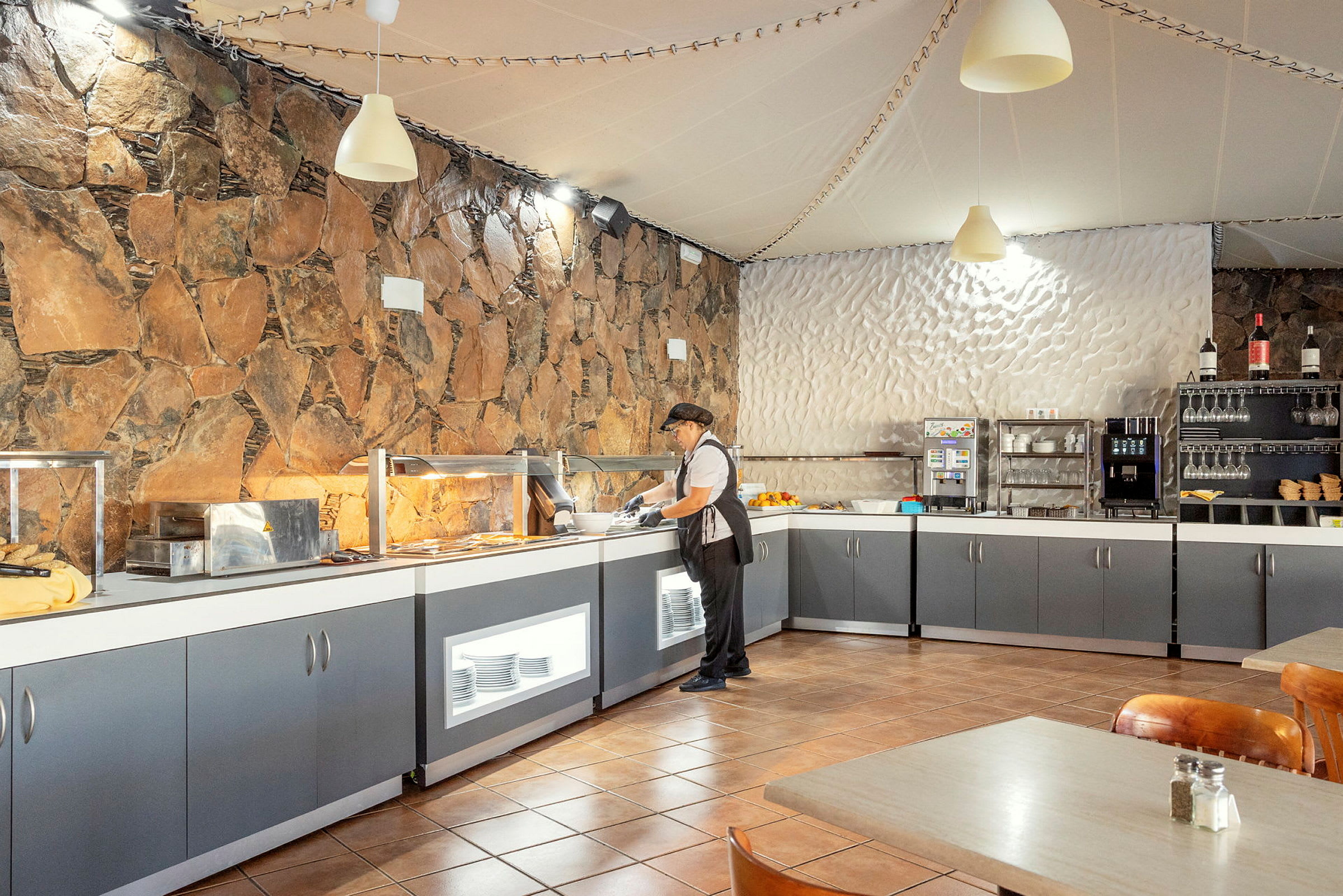 En frukostbuffé i en restaurang med stenmur och moderna faciliteter. (AI-genererad text)