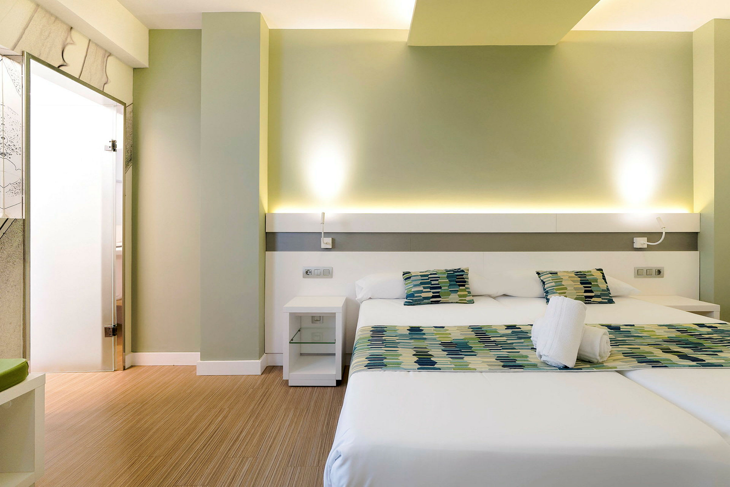 Modernt hotellrum med två enkelsängar och sittgrupp. (AI-genererad text)