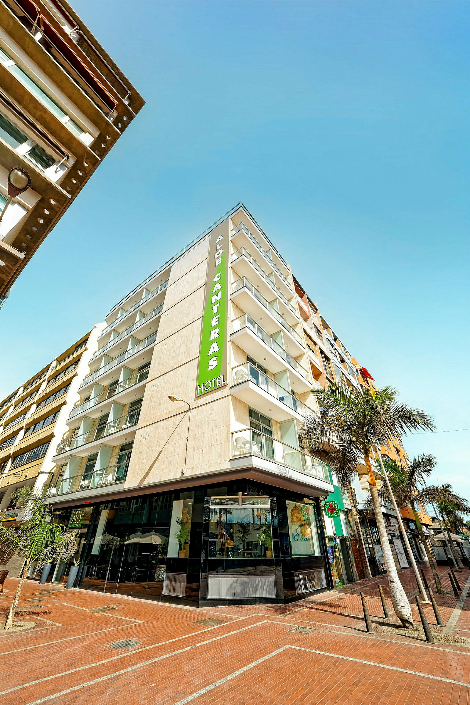 Ett modernt hotell med balkonger och en skylt som visar namnet Aloe Canteras. (AI-genererad text)
