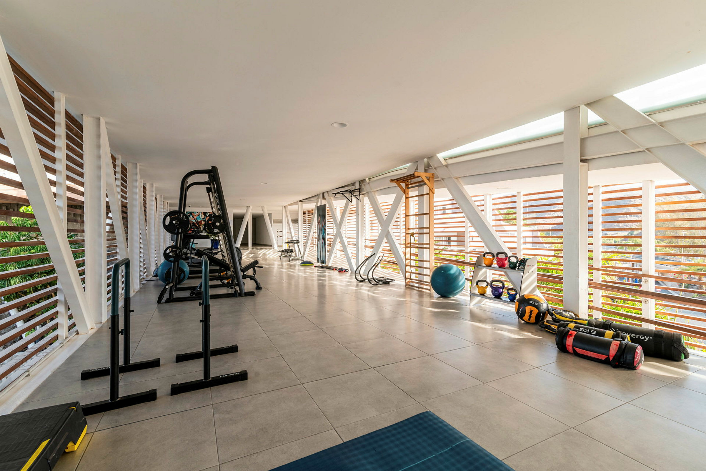 Bild på ett gym med träningsutrustning, rymligt och med mycket ljus. (AI-genererad text)