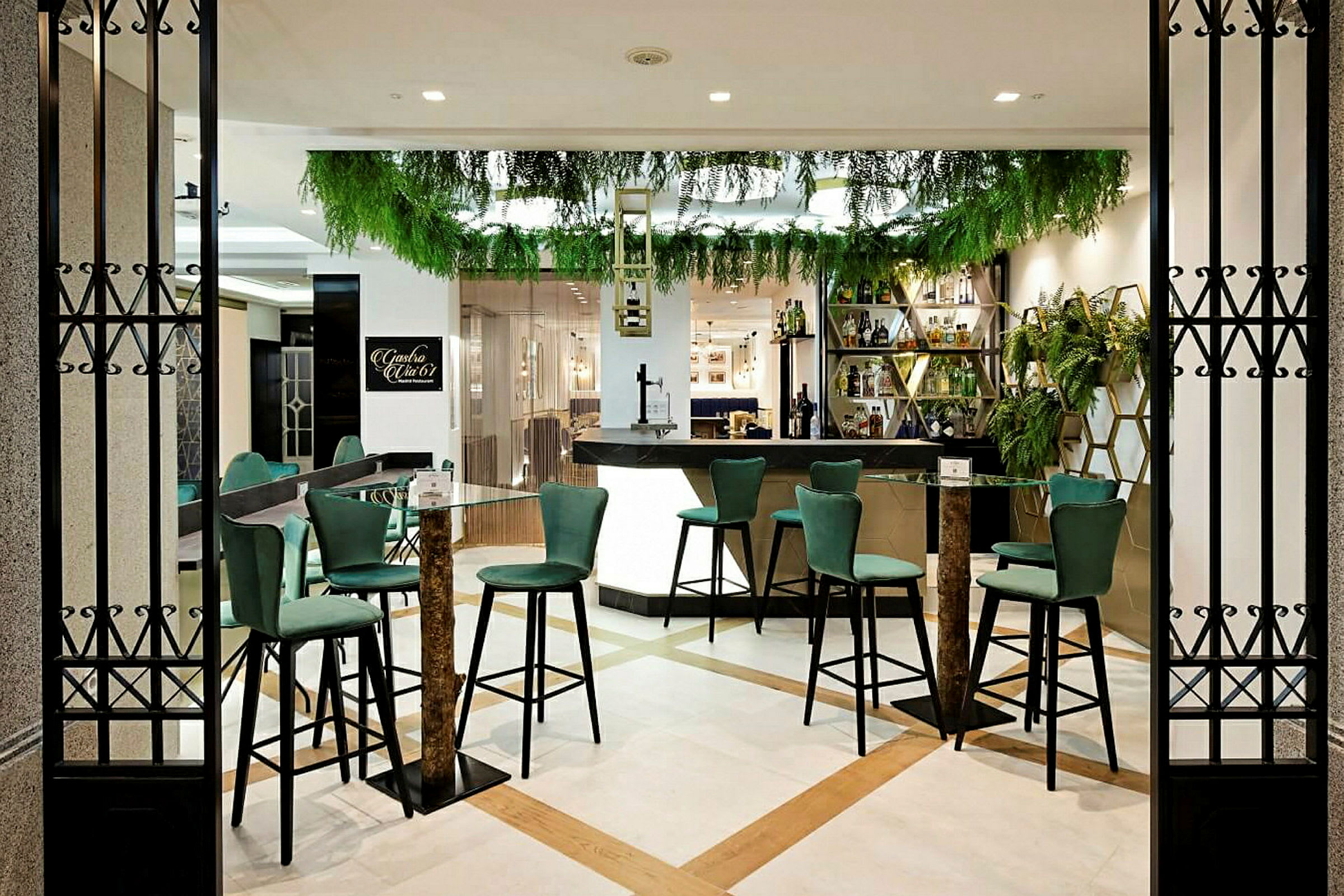 En modern bar med gröna stolar och växter som dekoration. (AI-genererad text)