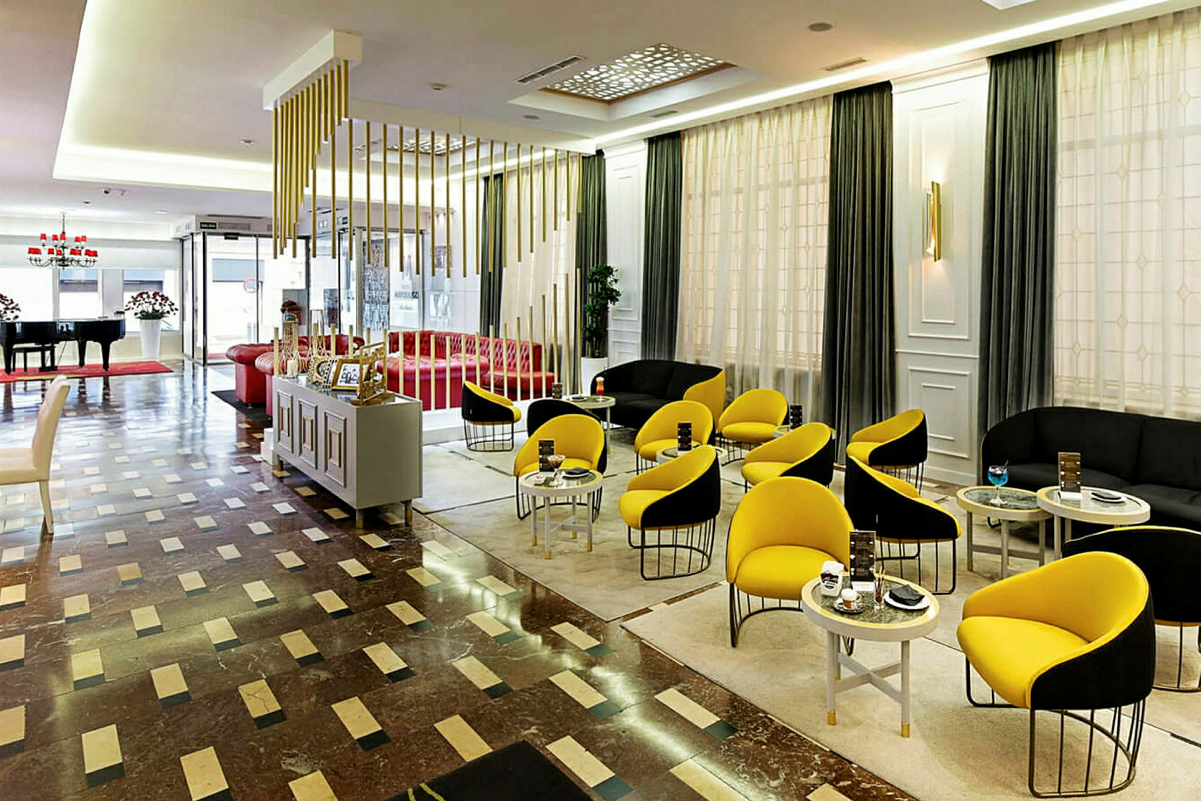 Ett modernt hotellobby med färgglada möbler och en piano hörna. (AI-genererad text)
