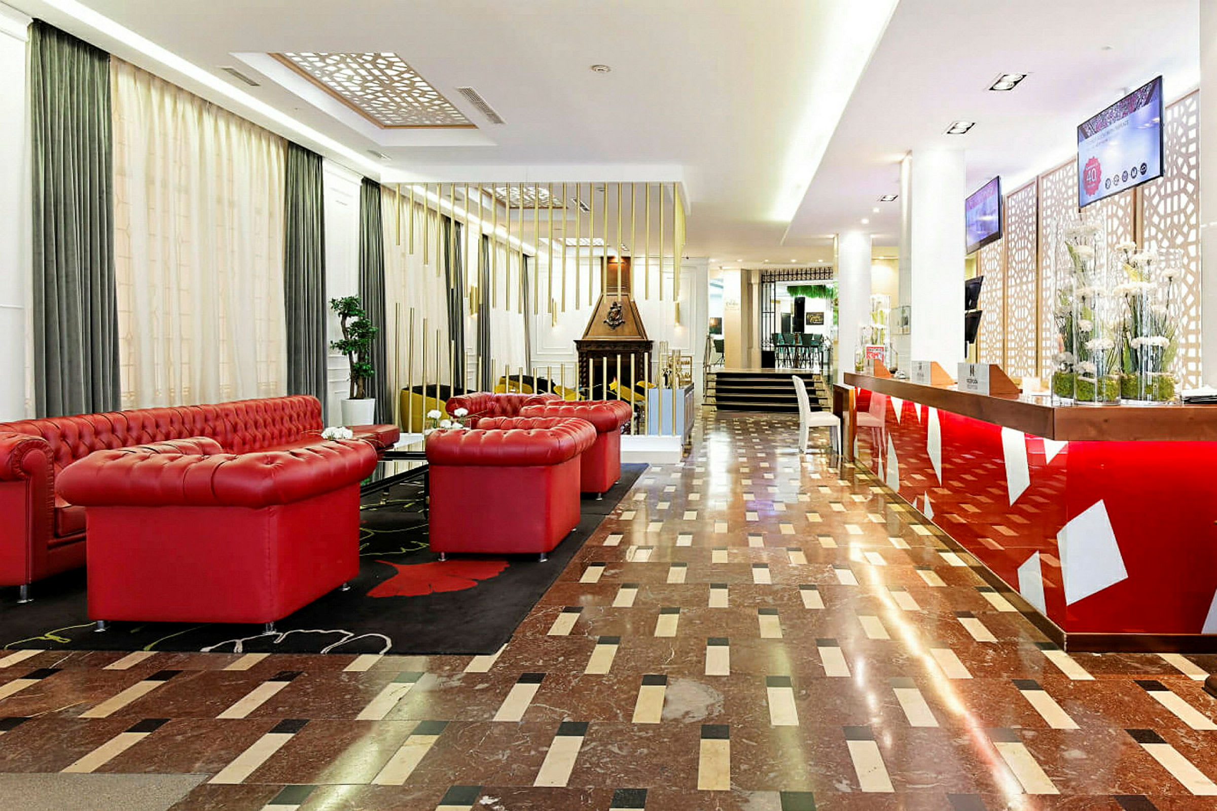 Hotellobby med röda soffor och receptionsdisk. (AI-genererad text)