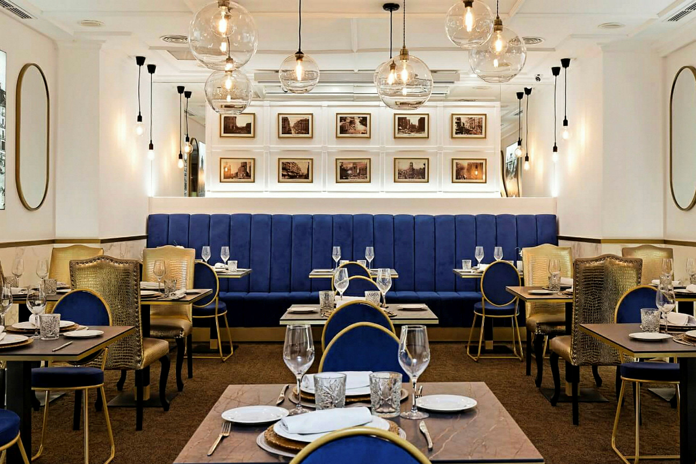 Interiör av en elegant restaurang med blå sittmöbler och gyllene detaljer. (AI-genererad text)