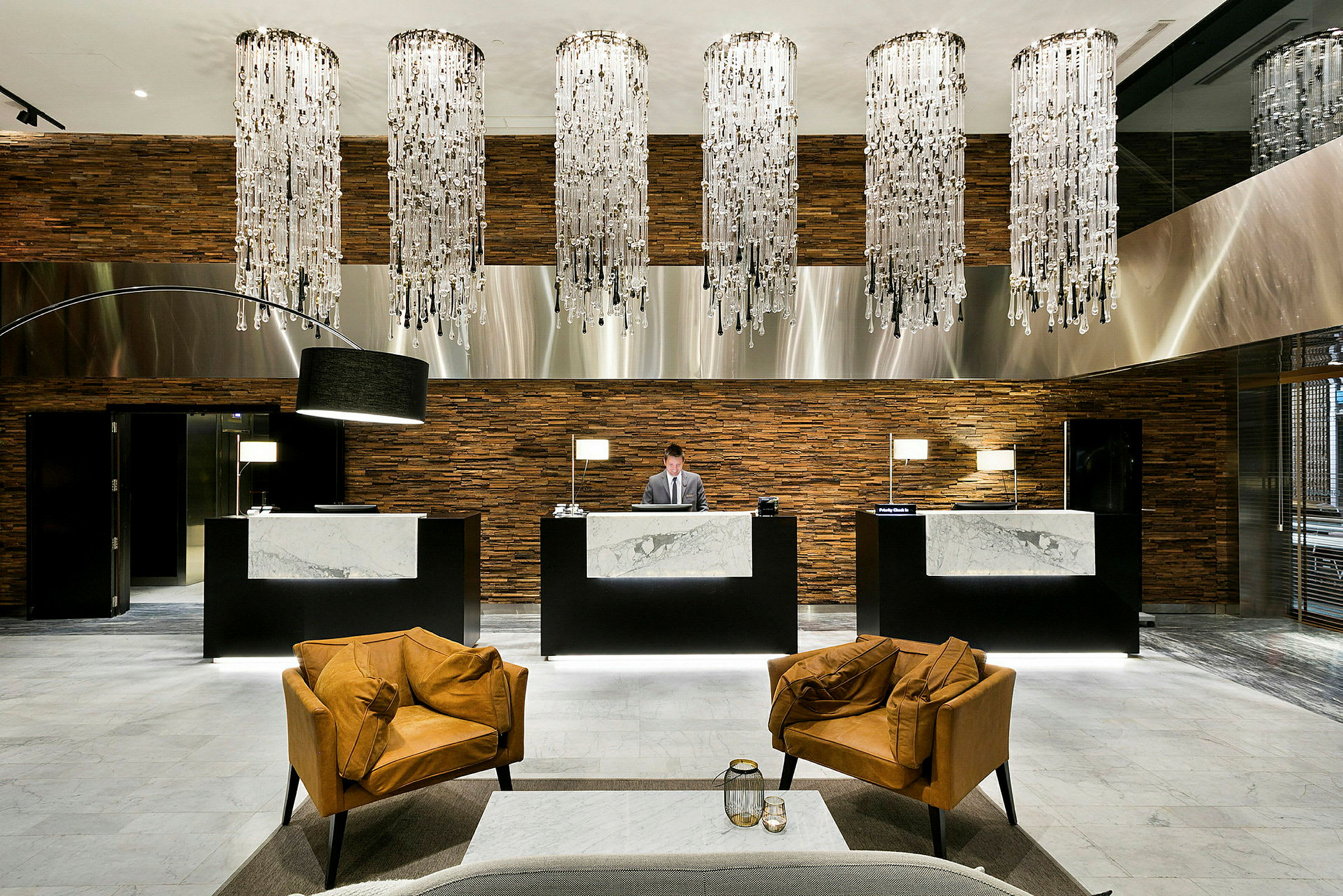 Reception i lyxig hotellmiljö med elegant inredning och kristallkronor. (AI-genererad text)