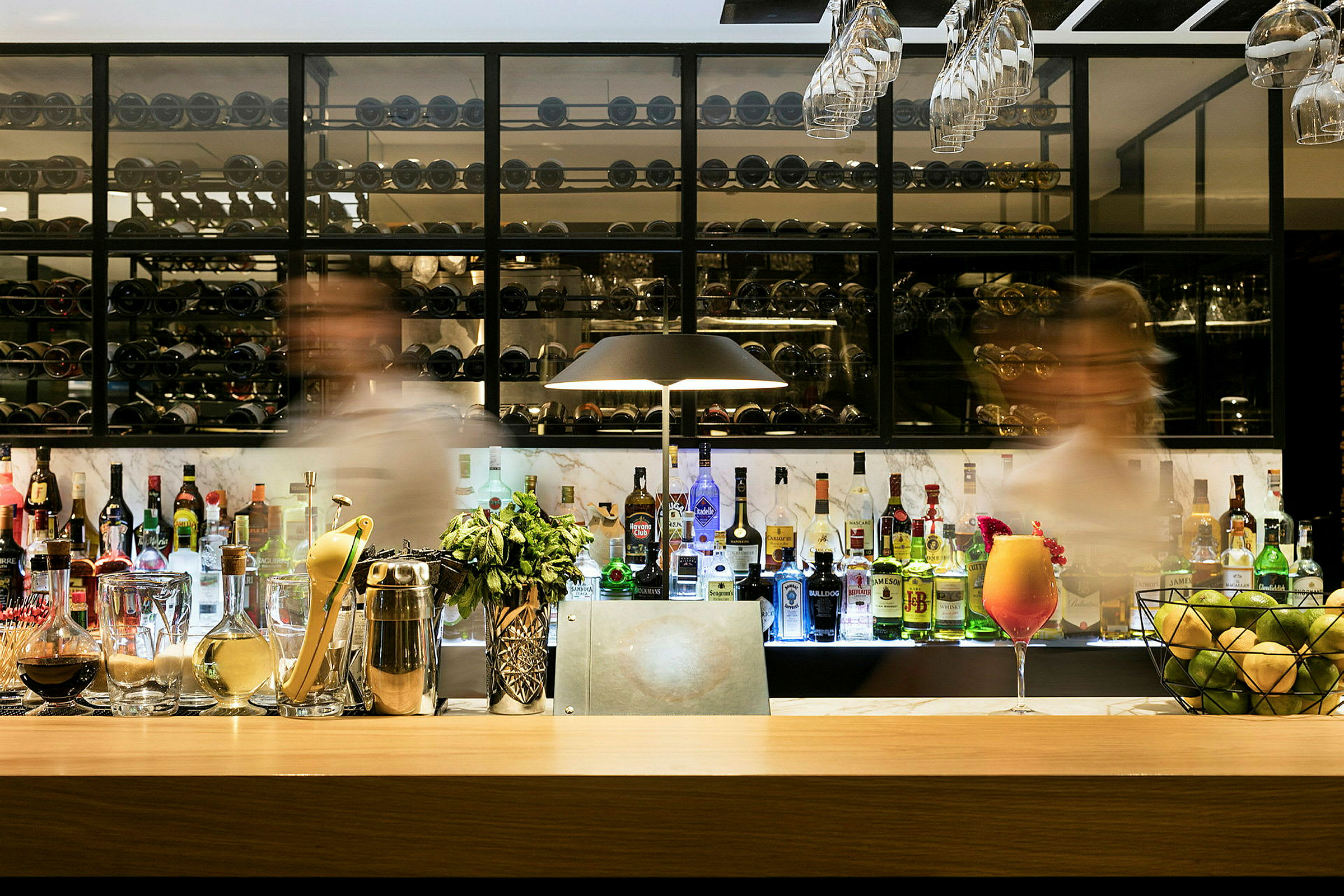 En elegant bar fylld med olika spritflaskor och tillbehör. (AI-genererad text)