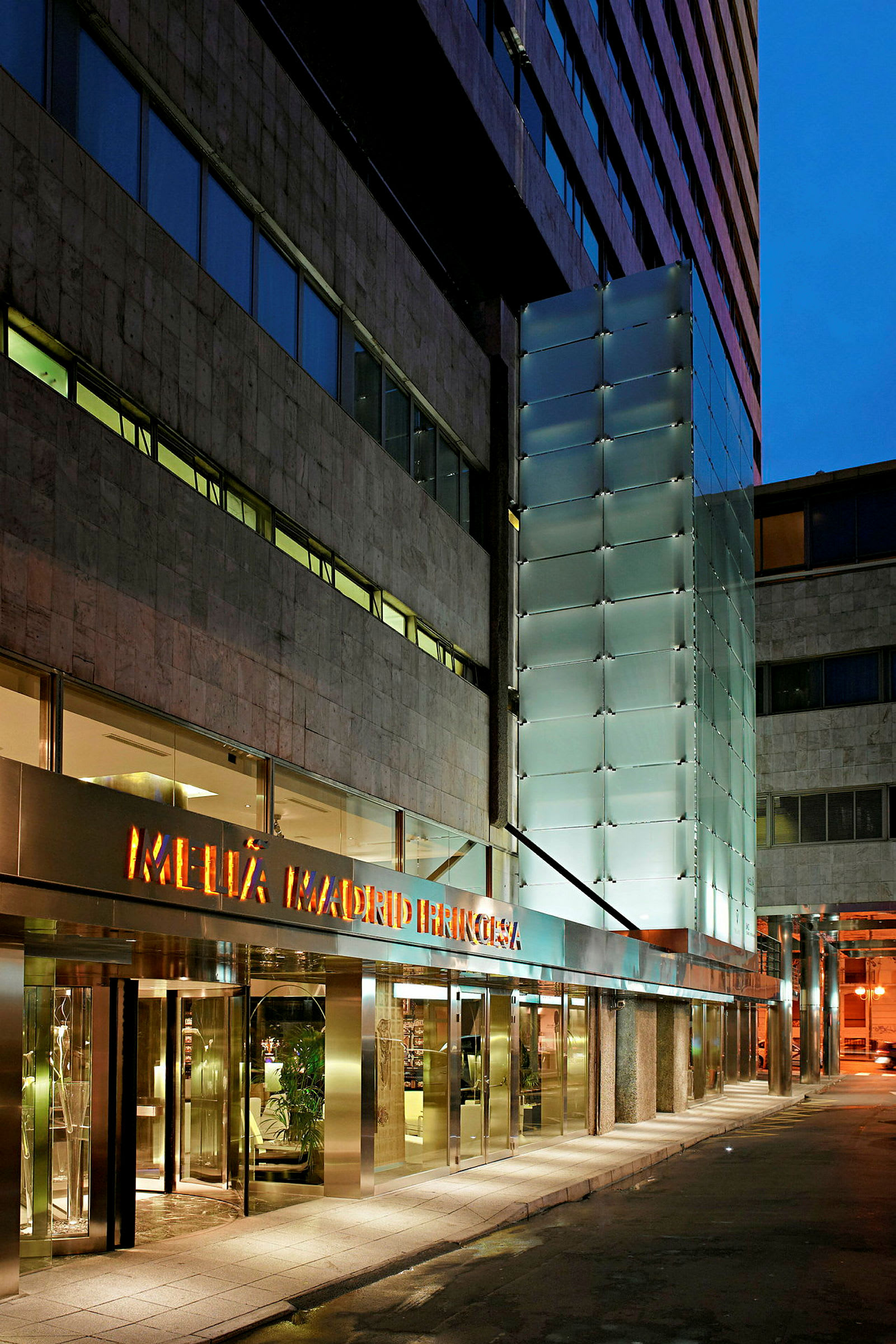 Entrén till ett hotell med glas- och marmorfasad. (AI-genererad text)