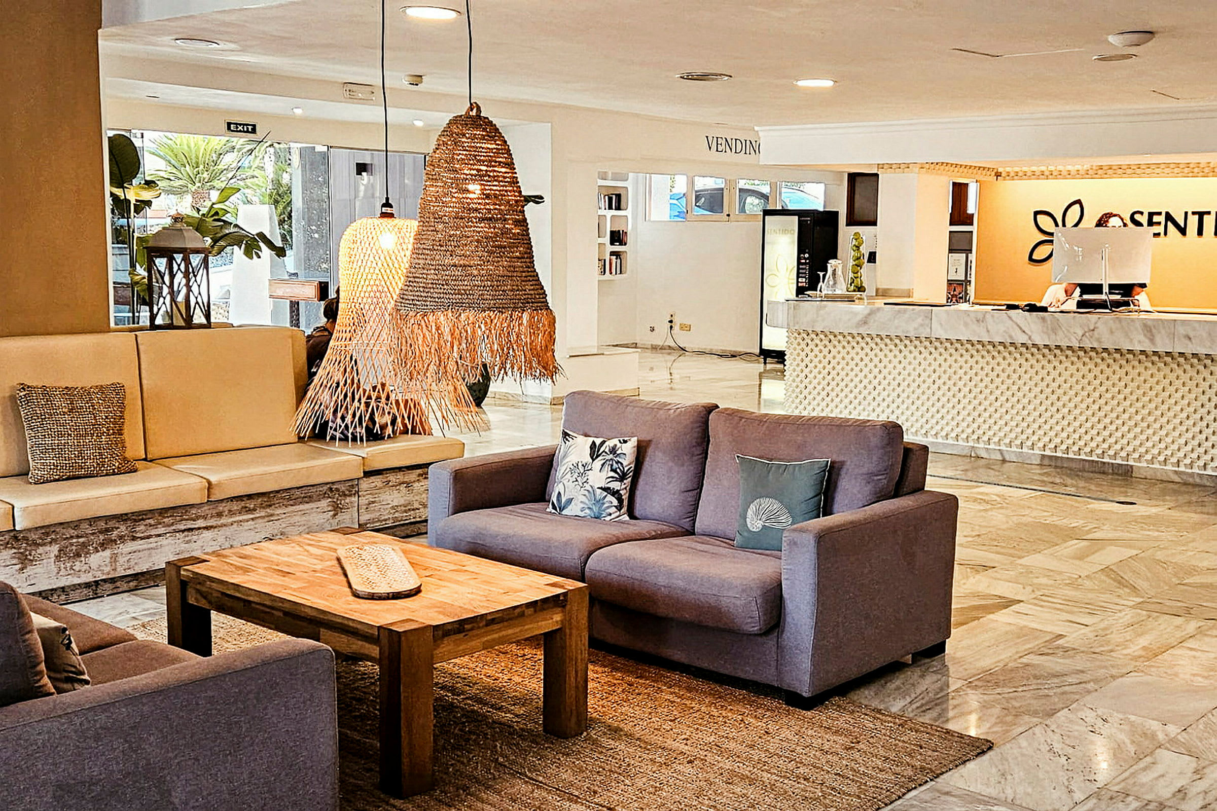 En hotellobby med sittgrupper, bord och reception. (AI-genererad text)