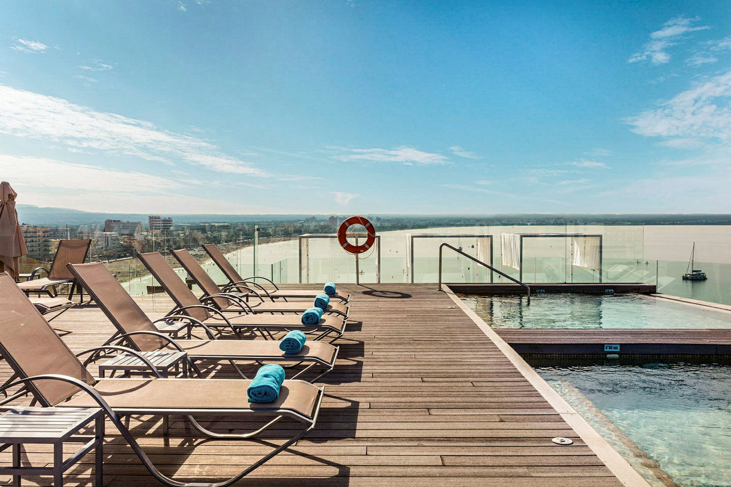 Solstolar vid en pool med utsikt mot havet. (AI-genererad text)
