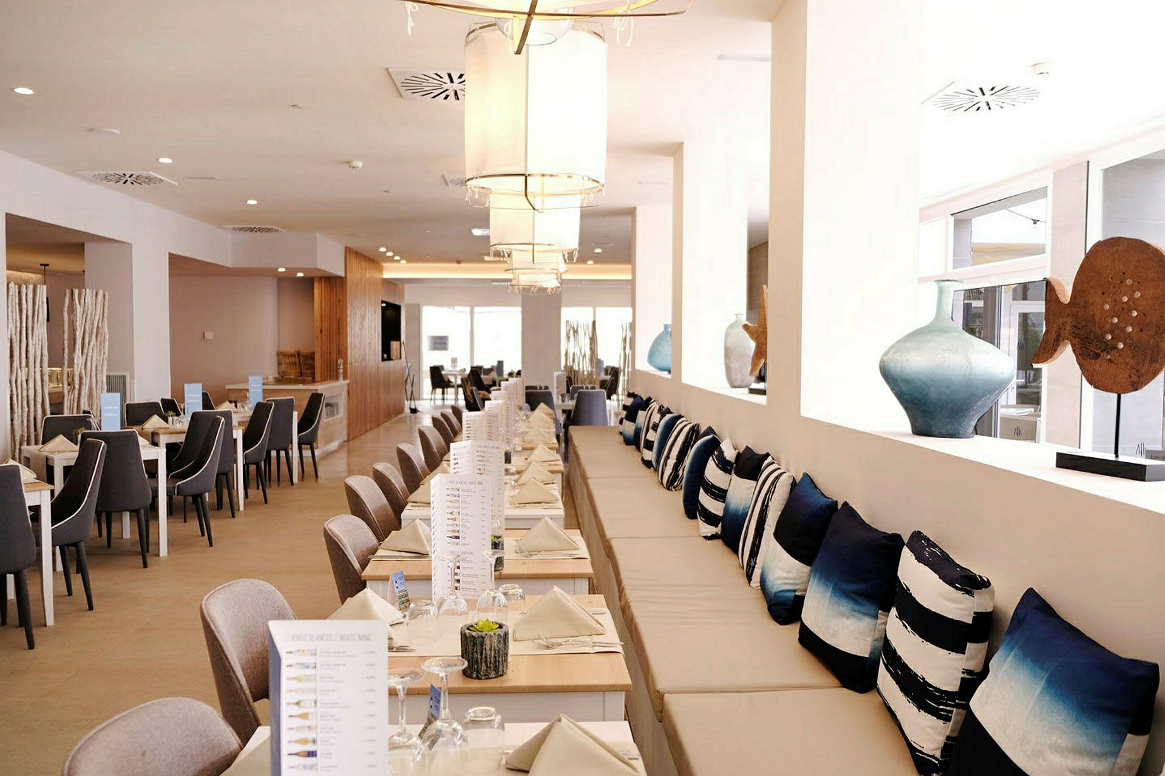 Restaurang med uppdukade bord och dekorationskuddar. (AI-genererad text)