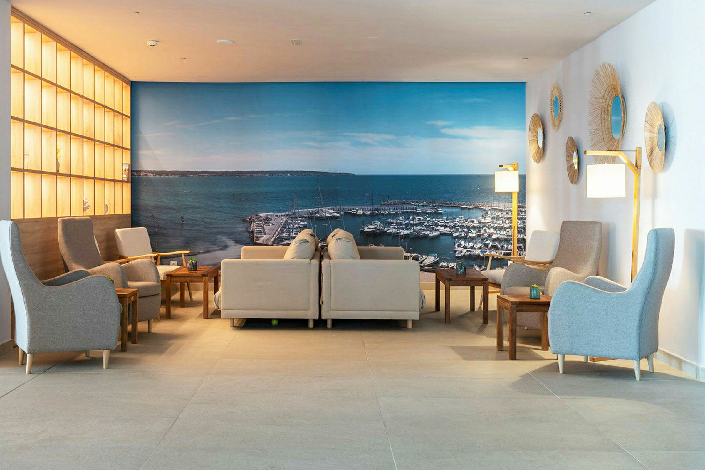 Lounge med soffor och stolar, vägg med bild av en småbåtshamn. (AI-genererad text)