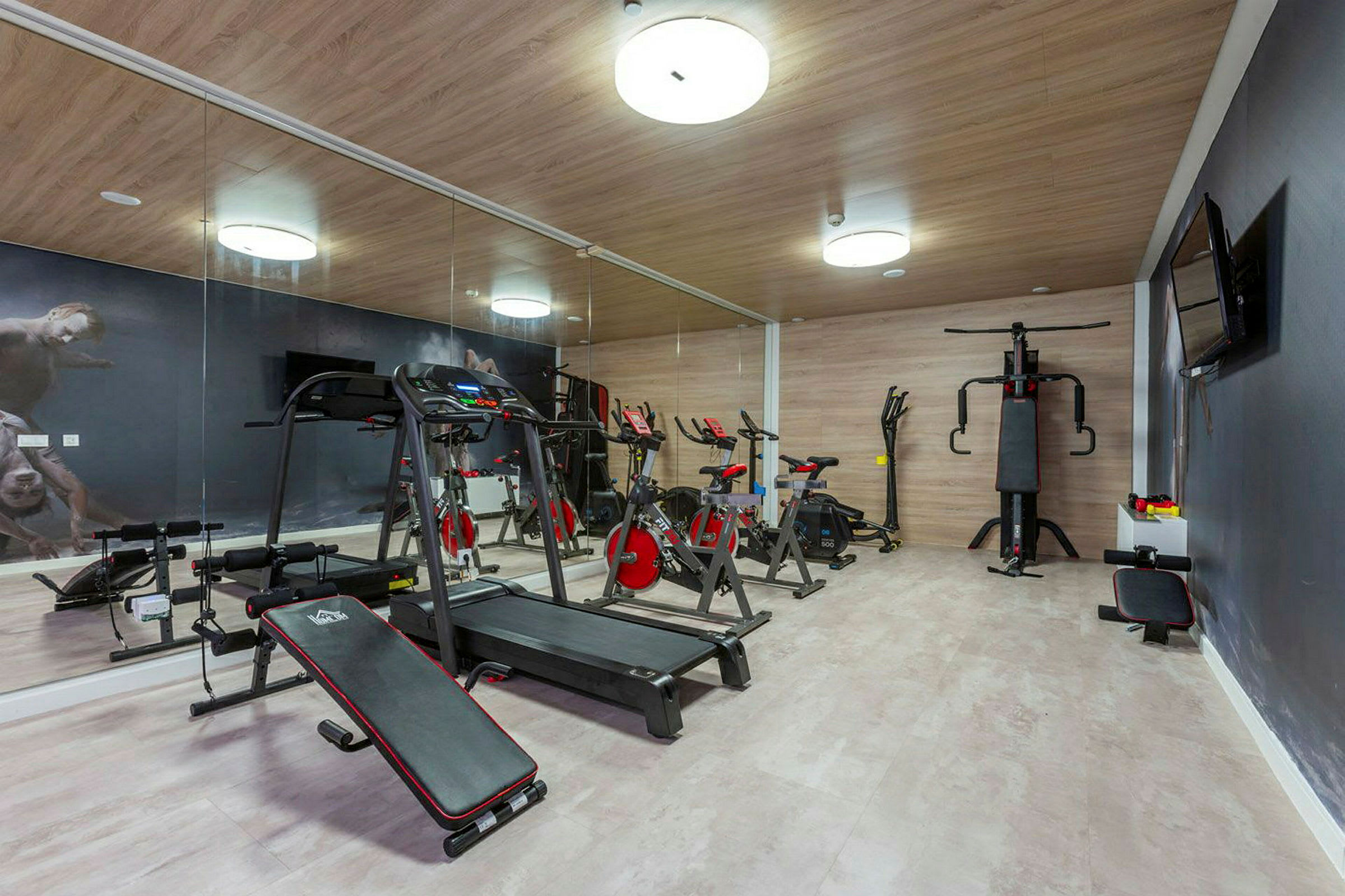 Bild av ett gym med träningsutrustning, inklusive löpband, träningscyklar och annan utrustning. (AI-genererad text)