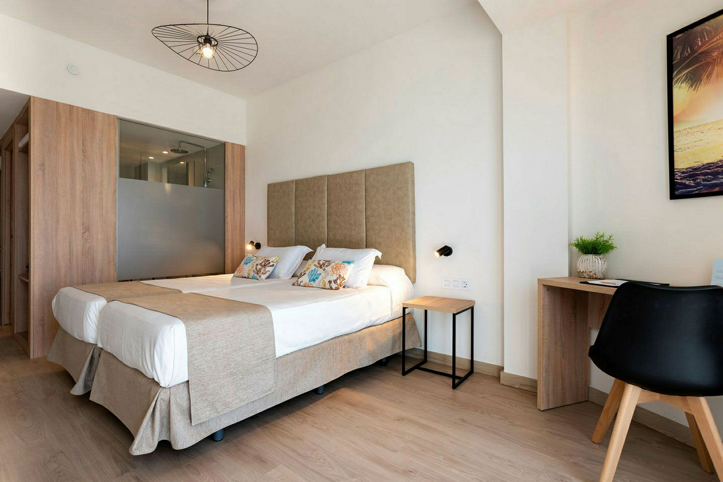 Ett ljust hotellrum med dubbelsäng och skrivbord. (AI-genererad text)