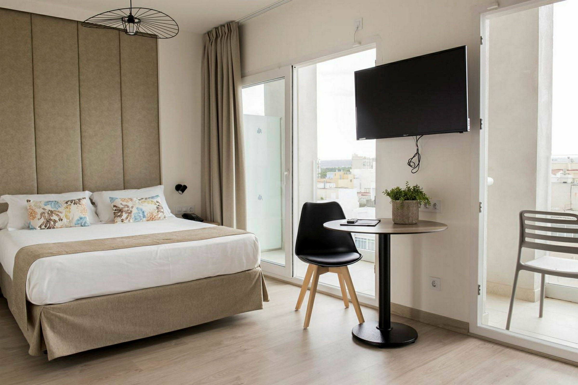 Hotellrum med en dubbelsäng, ett bord med stol och en TV på väggen. (AI-genererad text)