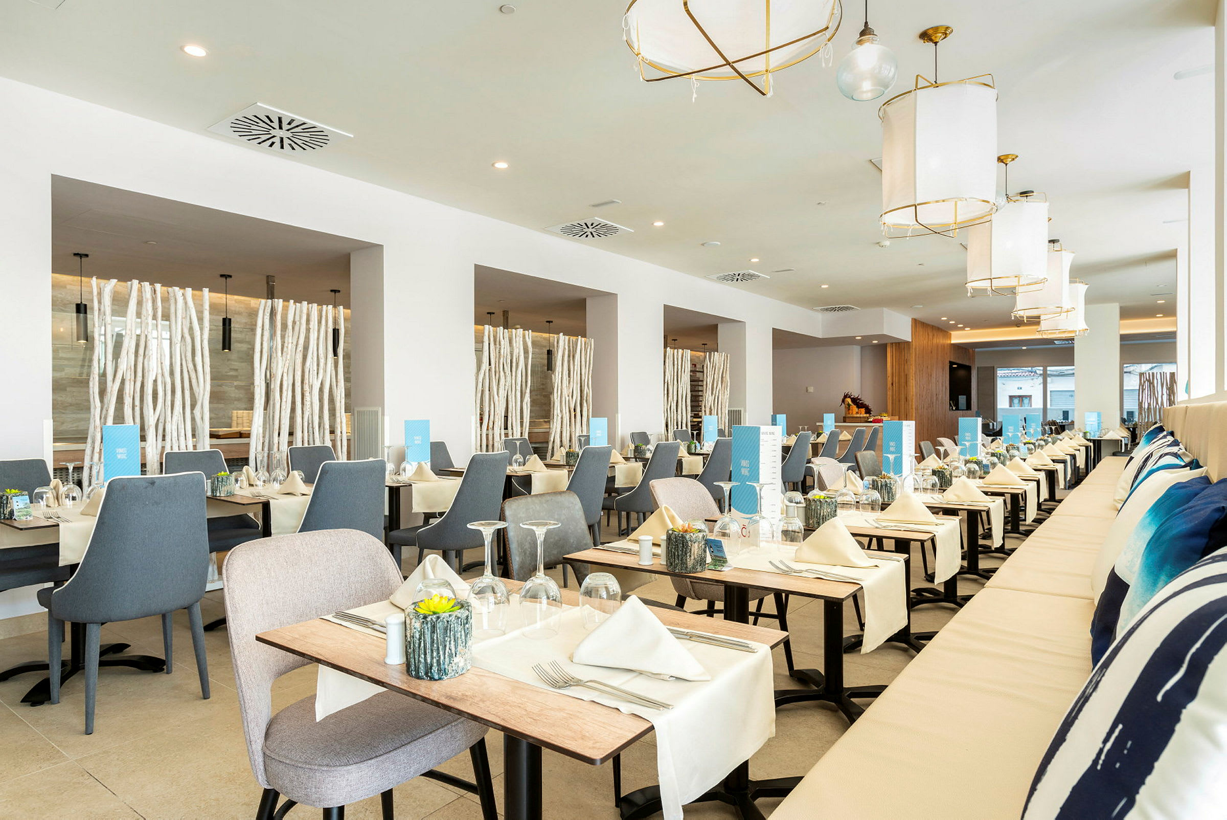 Ljus och modern restaurang med bord uppdukade med dukar och servetter. (AI-genererad text)