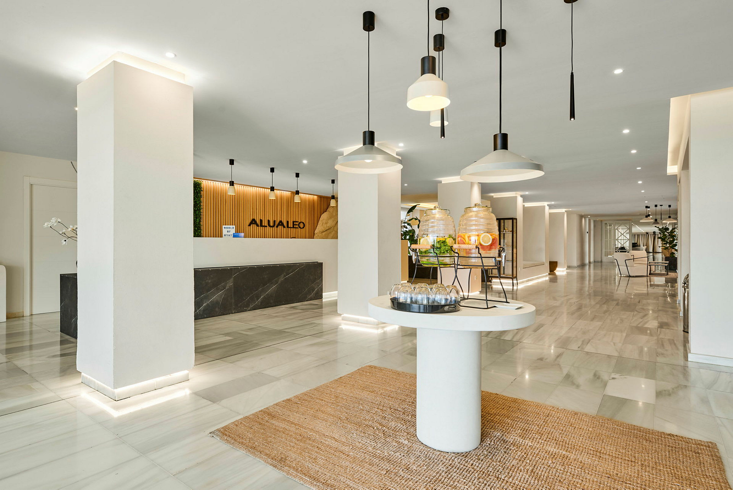 Hotellobby med receptionsdisk, en drinkstation och modern inredning. (AI-genererad text)