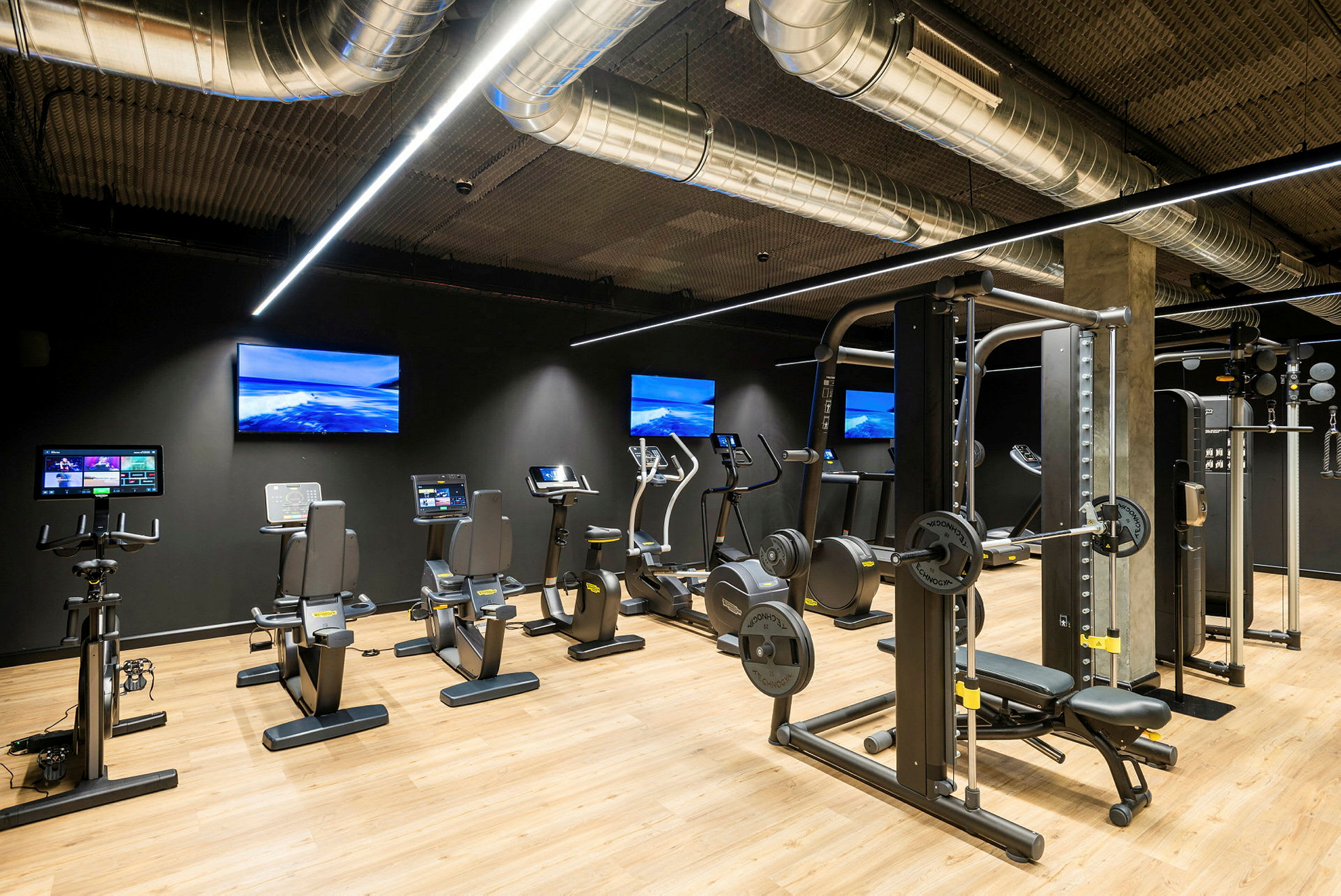 Ett gym med träningsutrustning som motionscyklar och styrketräningsmaskiner. (AI-genererad text)