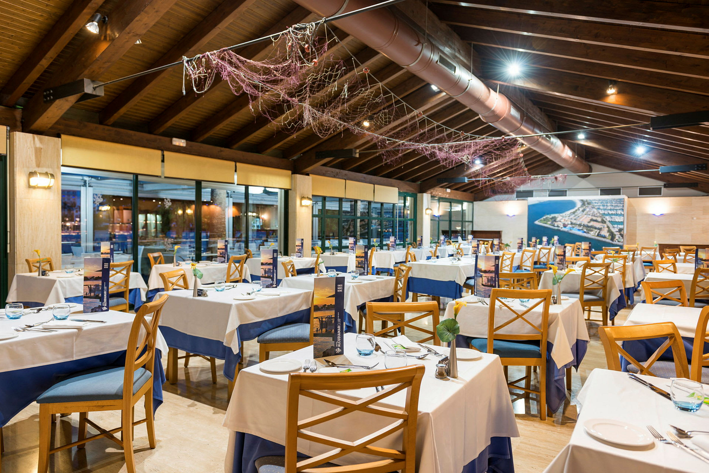 En restaurang med dukade bord och trästolar i en välbelyst lokal. (AI-genererad text)
