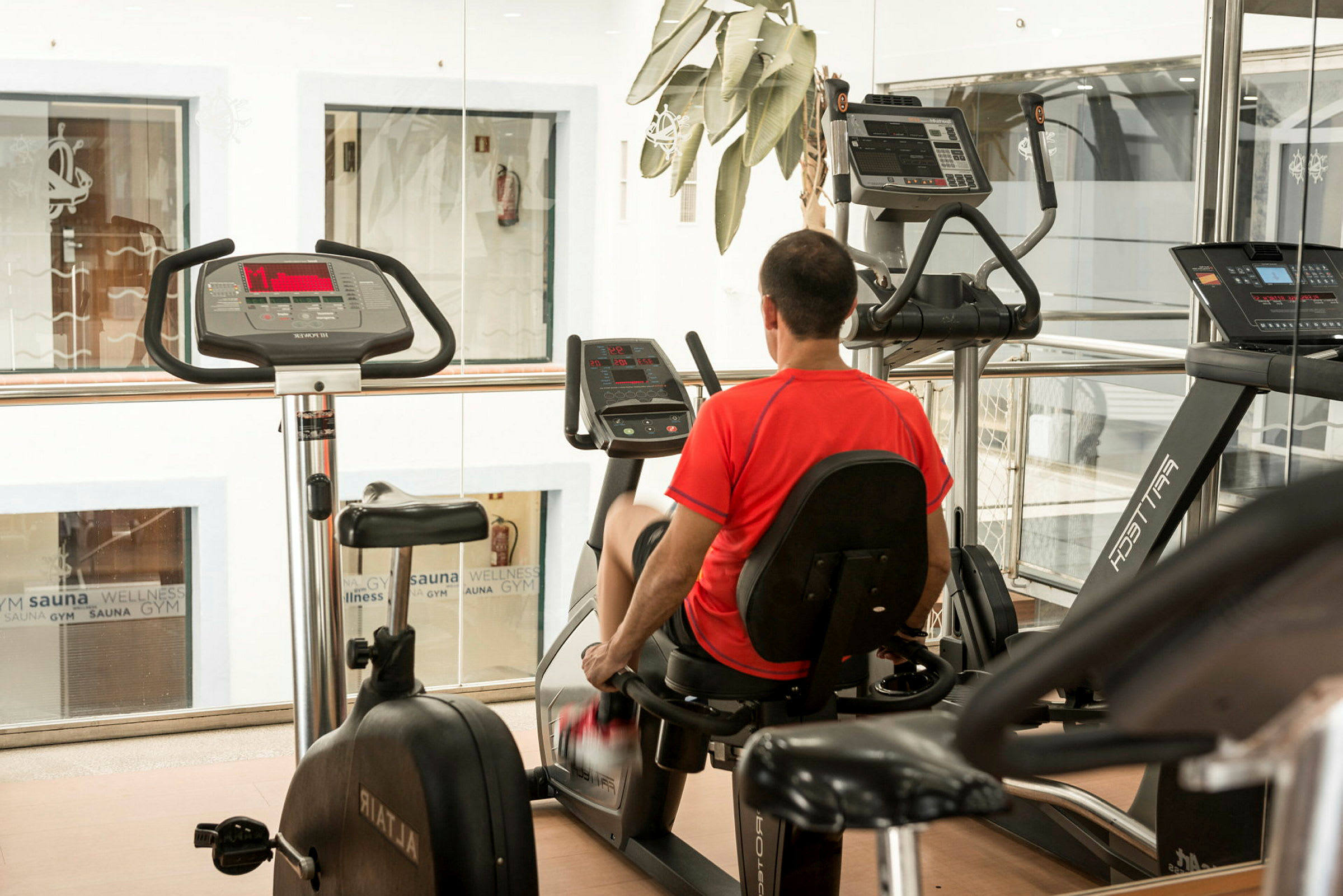 Man som använder sittande träningscykel i ett gym. (AI-genererad text)