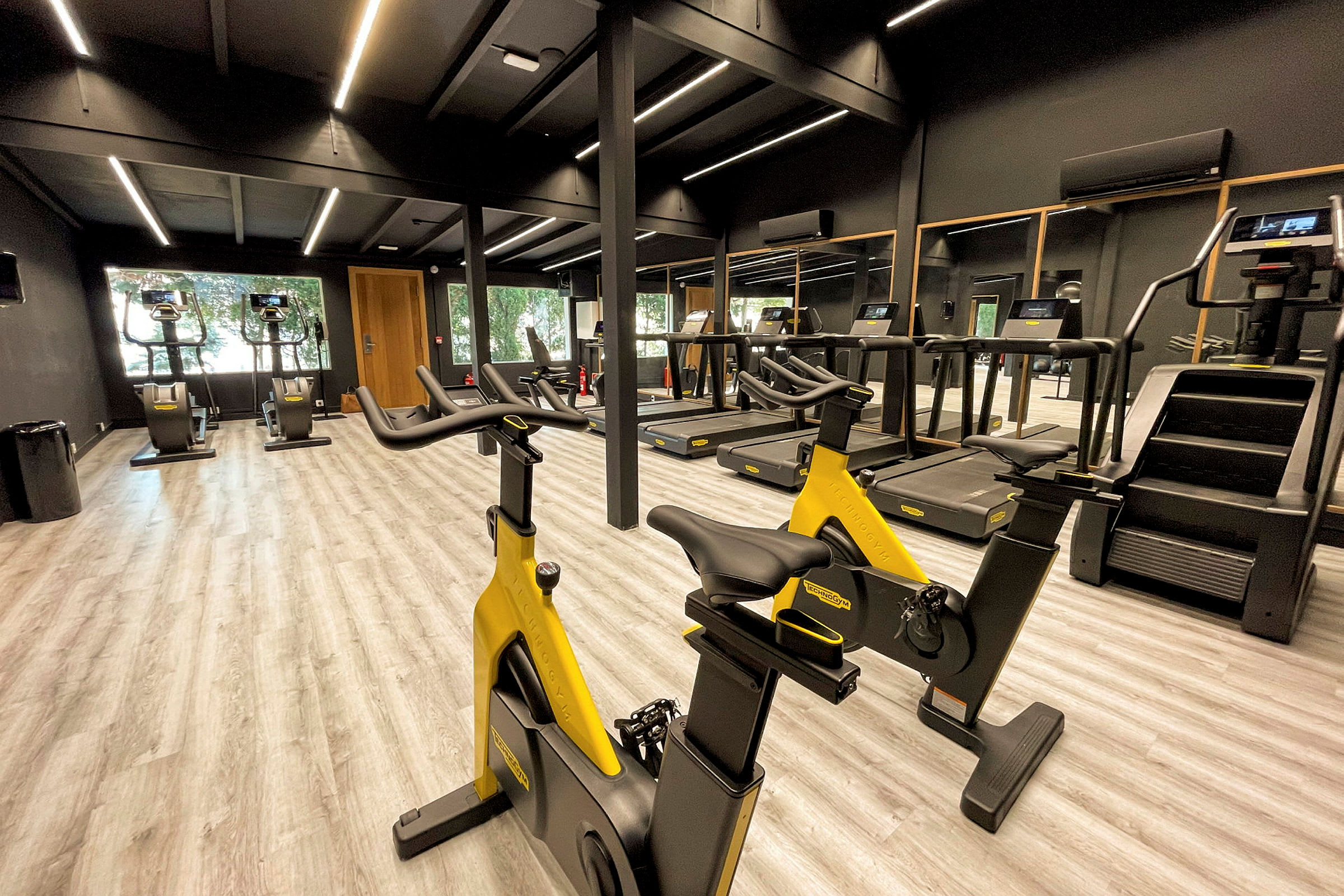 Ett gym med träningsmaskiner, inklusive motionscyklar och löpband. (AI-genererad text)