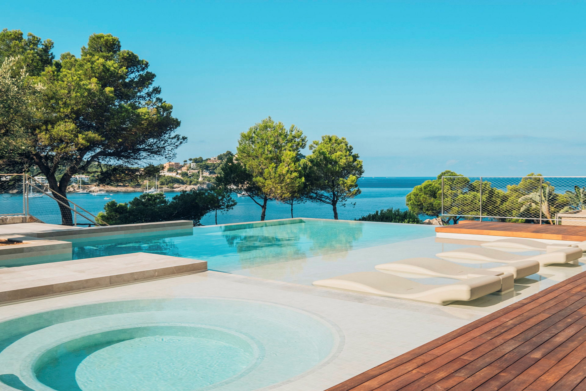 En pool med utsikt över havet och omgivande grönska. (AI-genererad text)