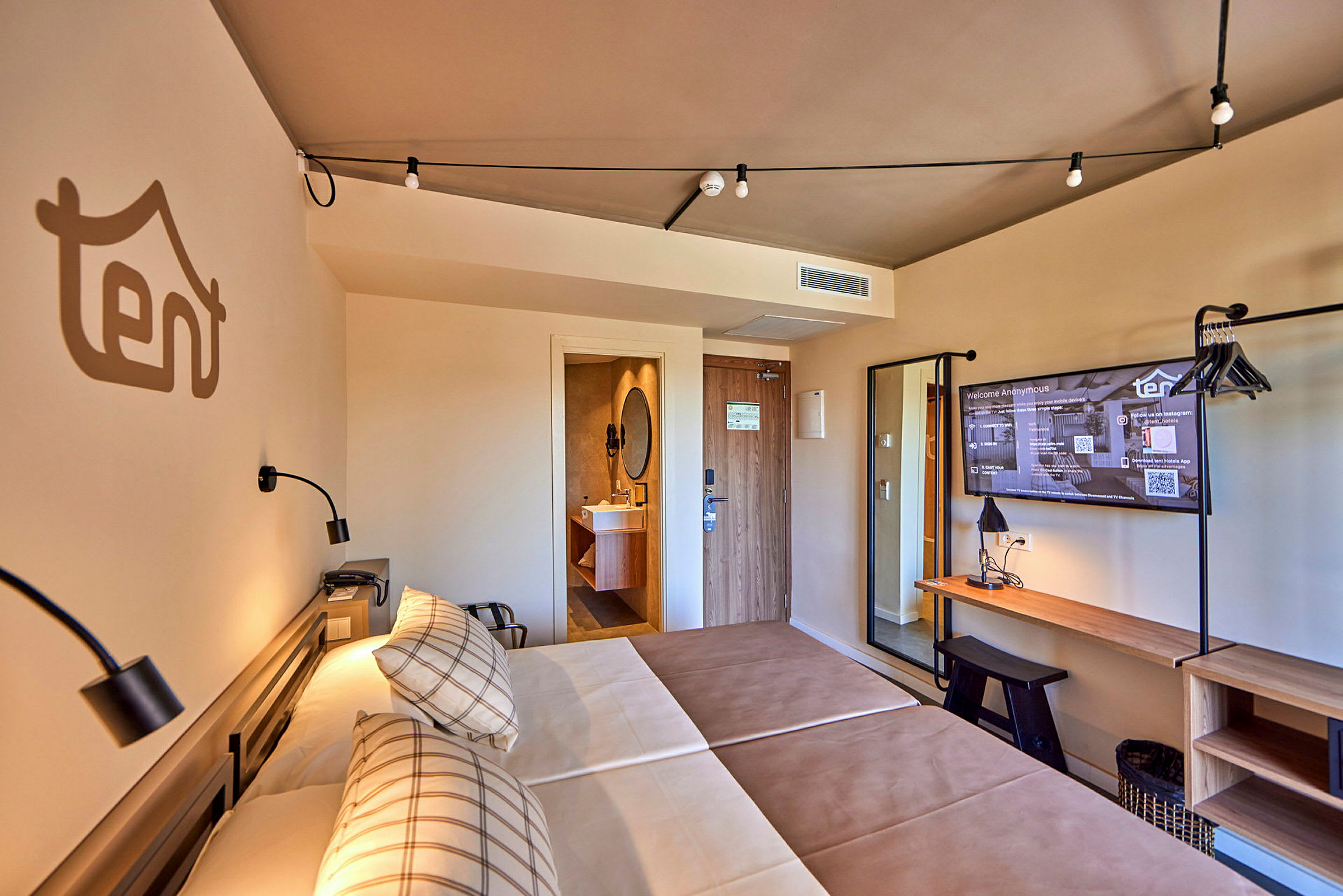 Ett hotellrum med två sängar, en TV och ett skrivbord. (AI-genererad text)