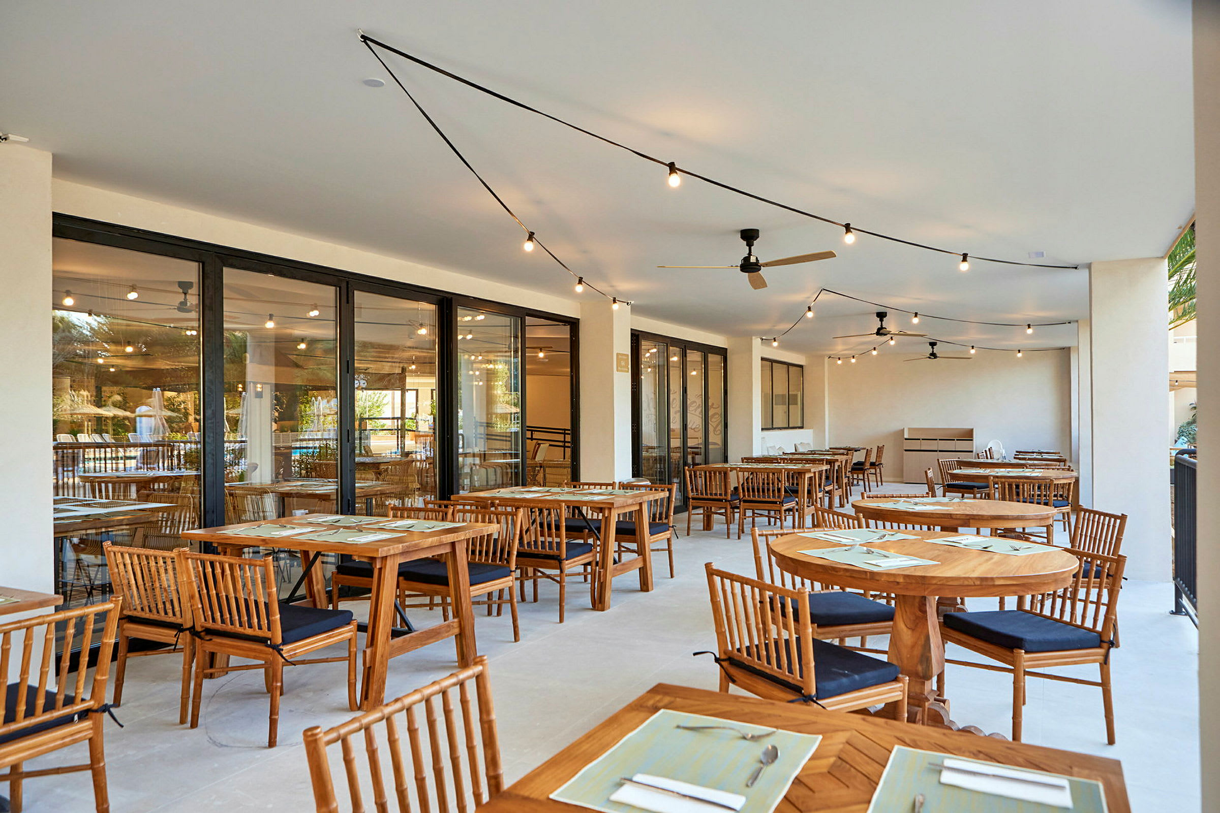 Utomhusrestaurang med bord och stolar av trä. (AI-genererad text)
