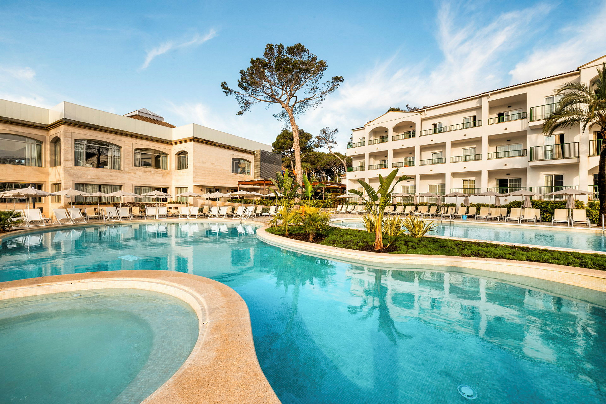 Bild av hotellområde med en pool, solstolar och en byggnad med flera våningar. (AI-genererad text)