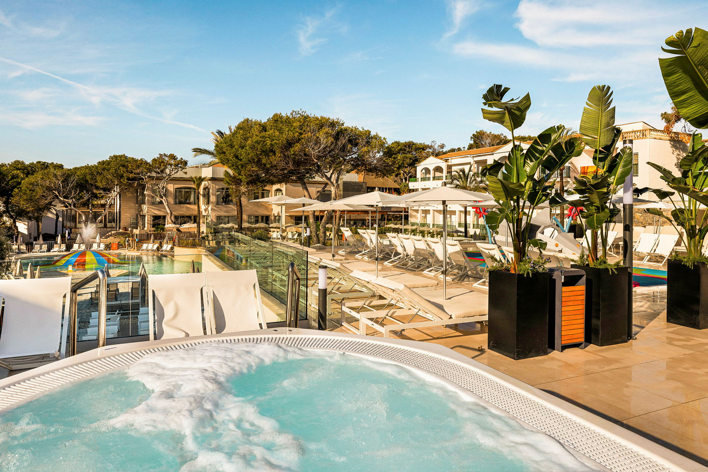 Utomhusområde med pool, solstolar och grönska vid ett semesterhotell. (AI-genererad text)