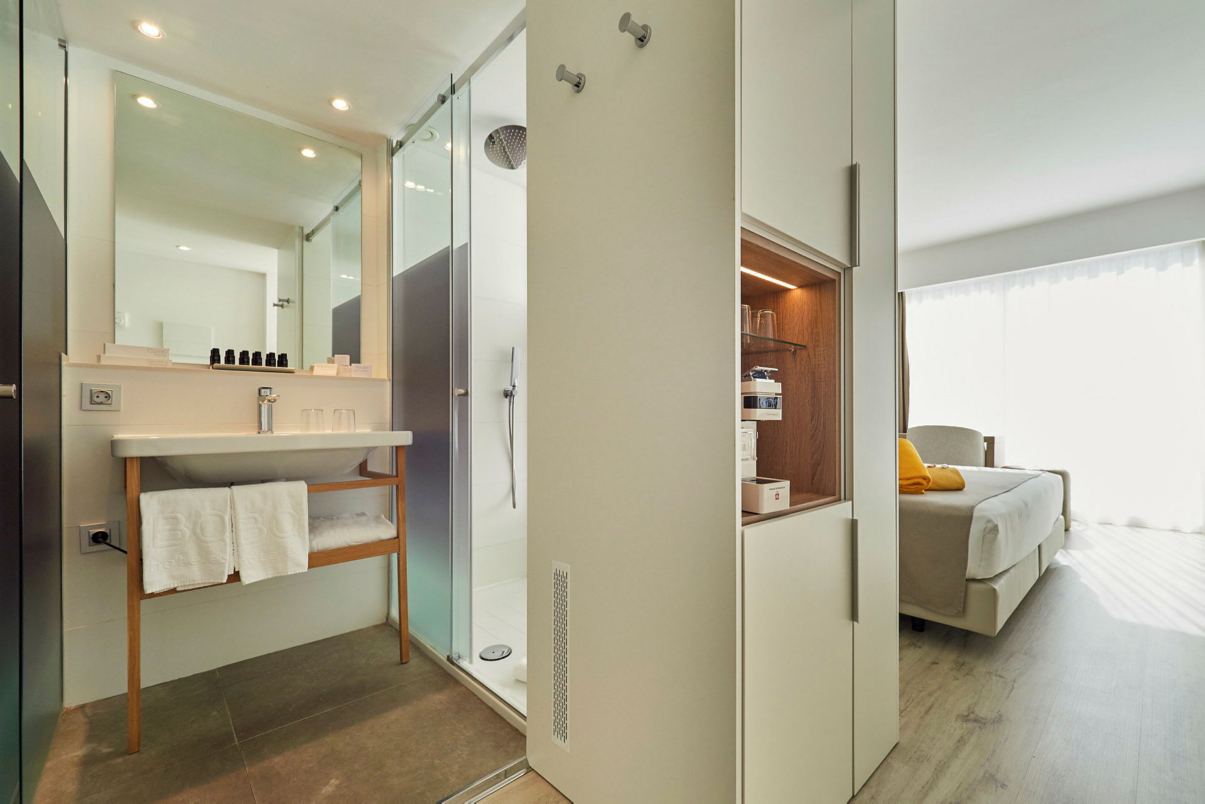 Ett hotellrum med ett modernt badrum och en säng. (AI-genererad text)