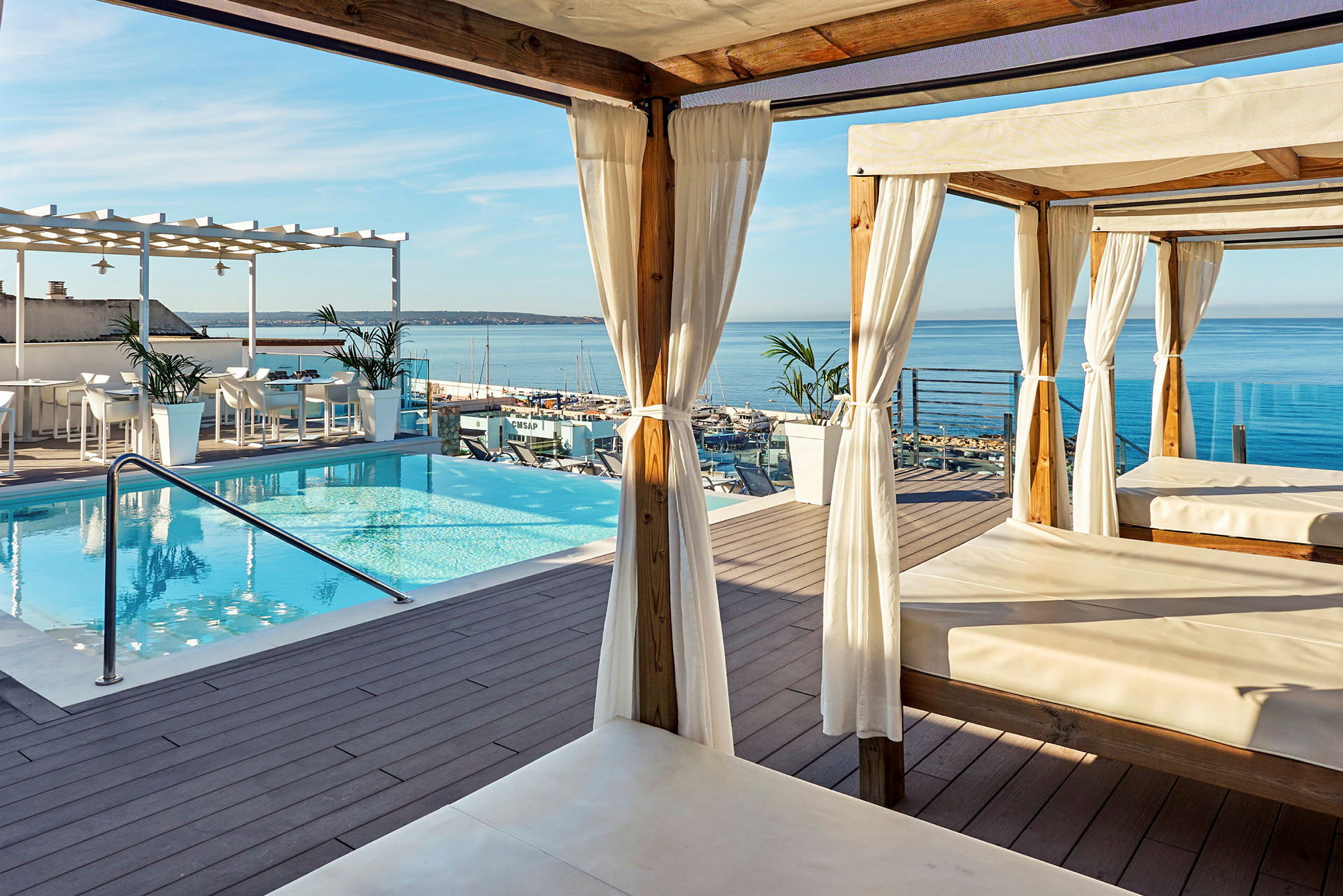 Terrass med pool, cabanas och utsikt över havet. (AI-genererad text)