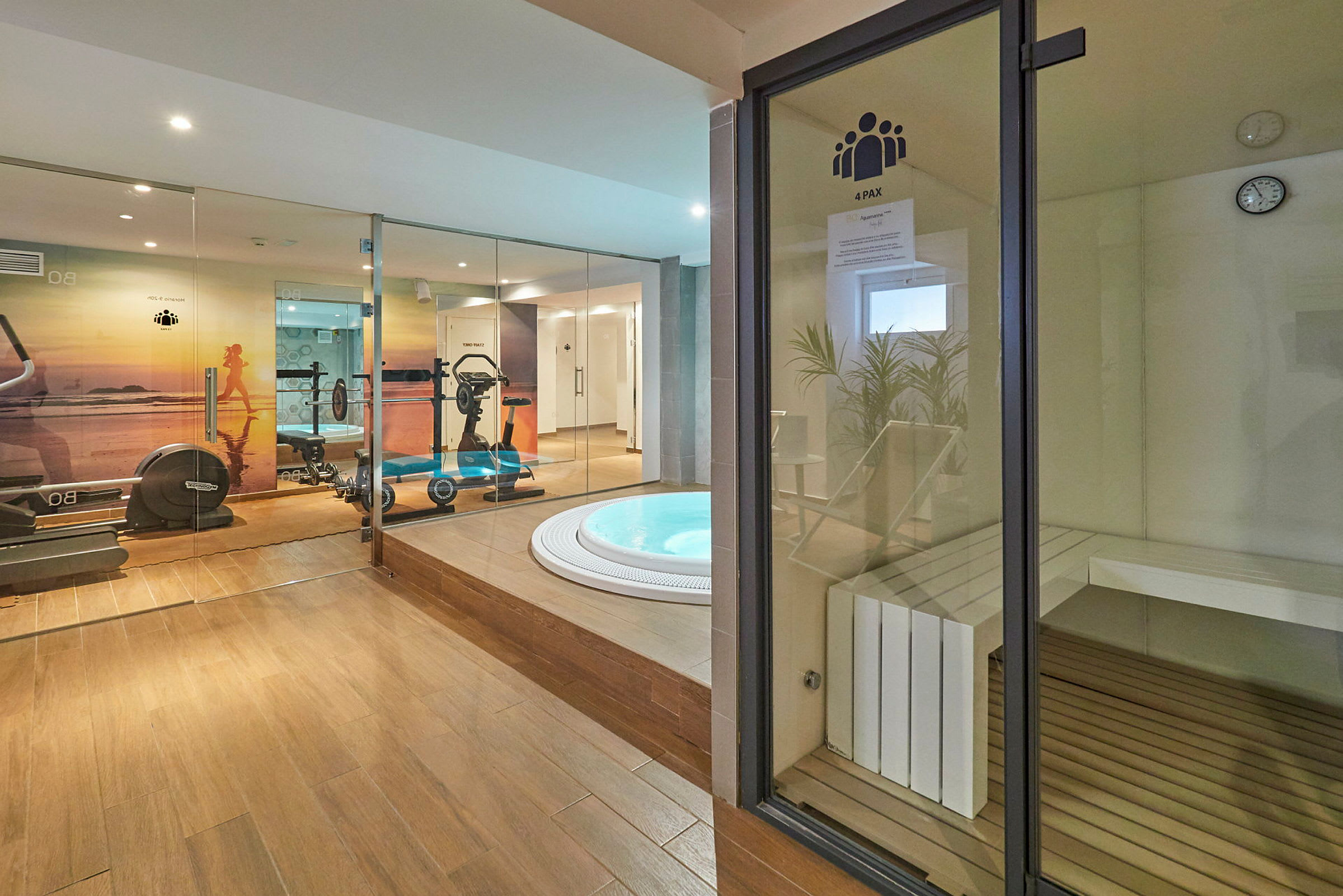Bild av ett gym med viktutrustning, motionscykel, jacuzzi och bastu. (AI-genererad text)