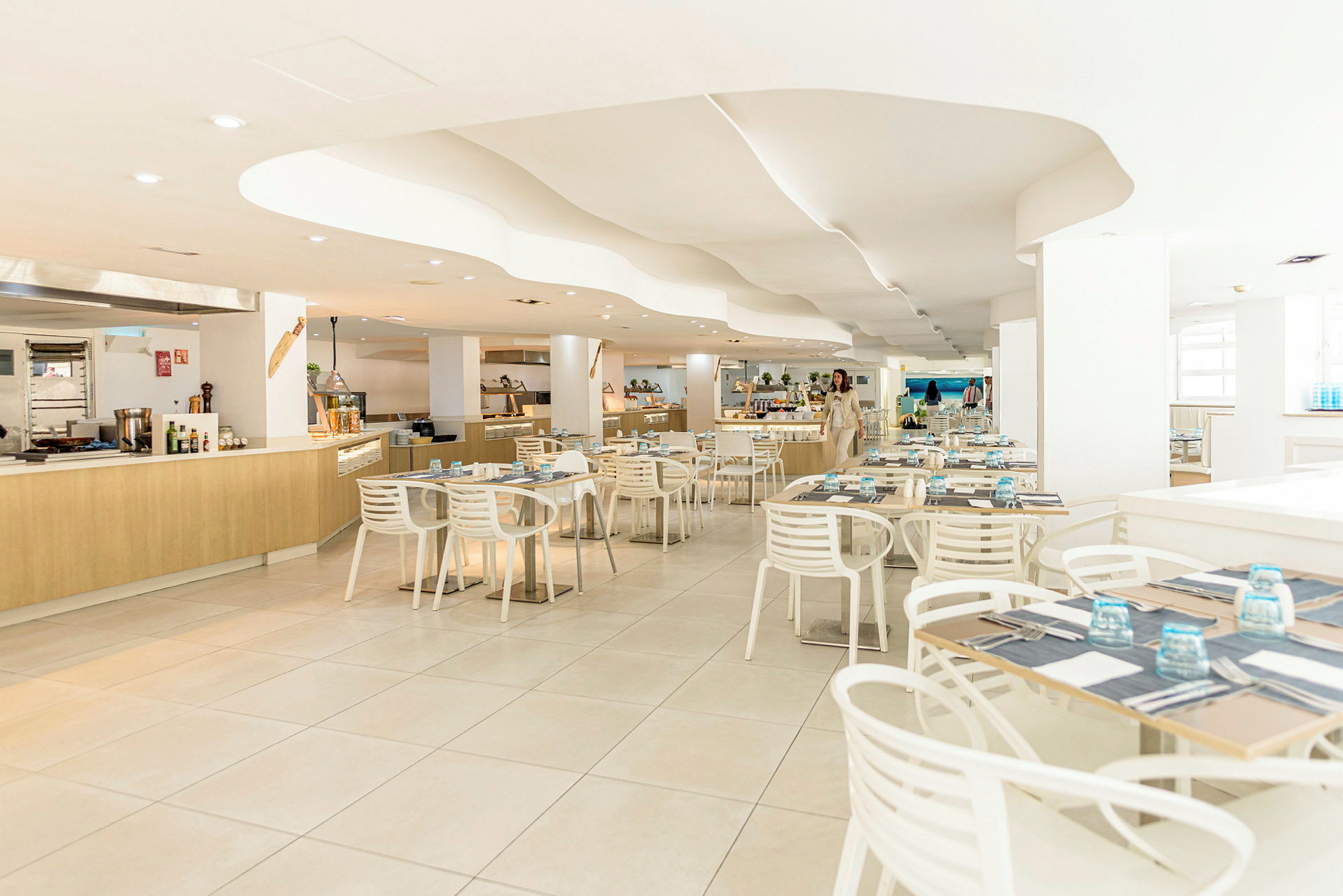 Interiör av en modern restaurang med ljusa möbler och dukade bord. (AI-genererad text)