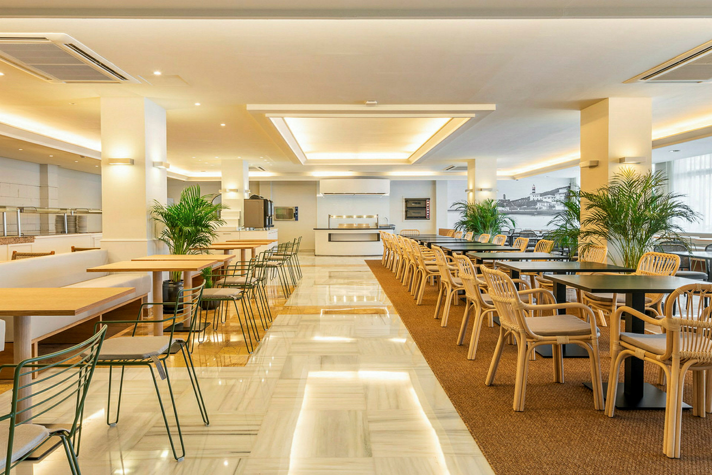 En rymlig restaurang med bord och stolar i trä och metall, samt dekorativ växtlighet. (AI-genererad text)