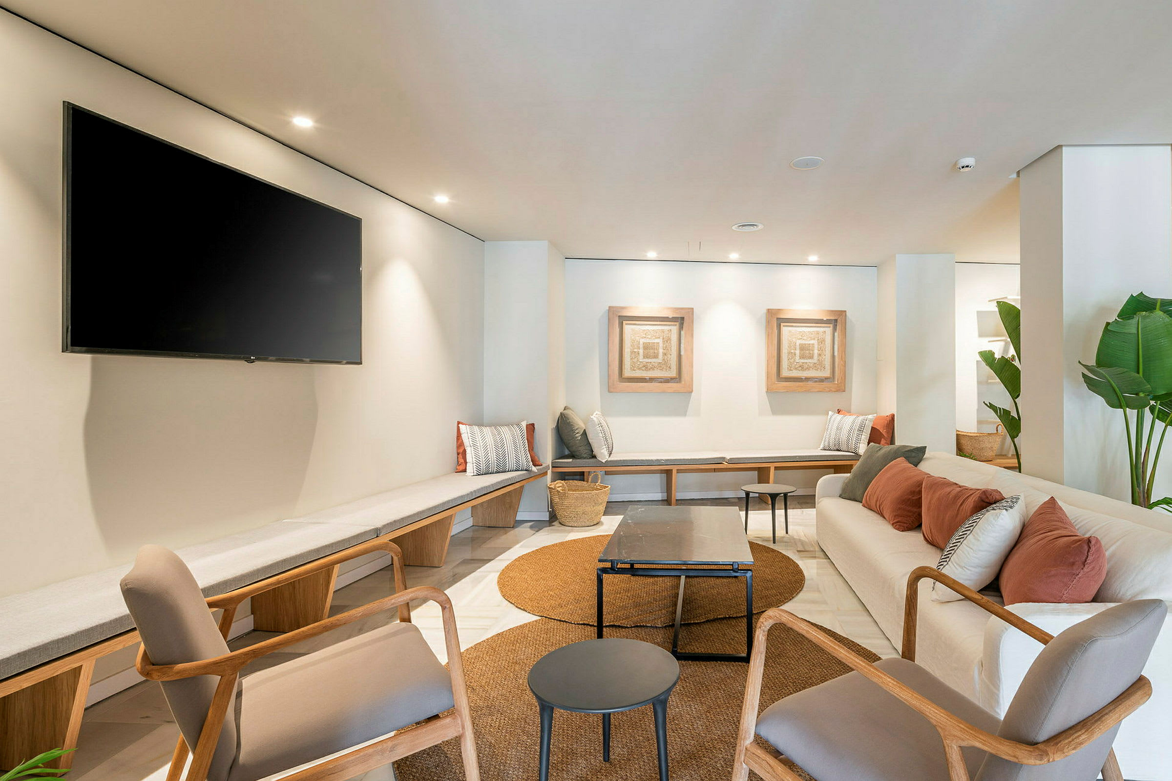 Modernt möblerad lounge med sittplatser, bord och väggdekoration. (AI-genererad text)