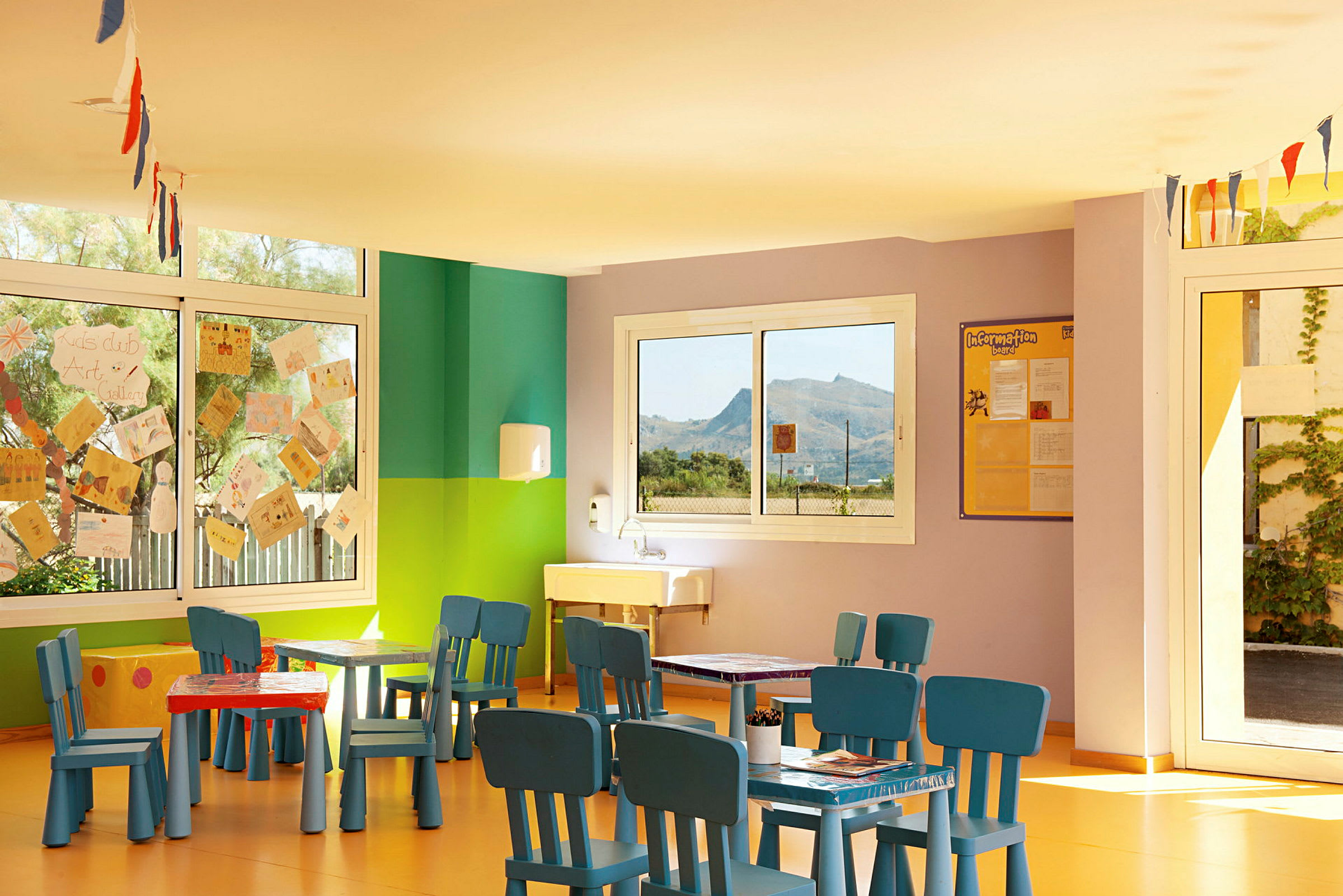 Ett färgglatt lekrum med bord och stolar för barn. (AI-genererad text)