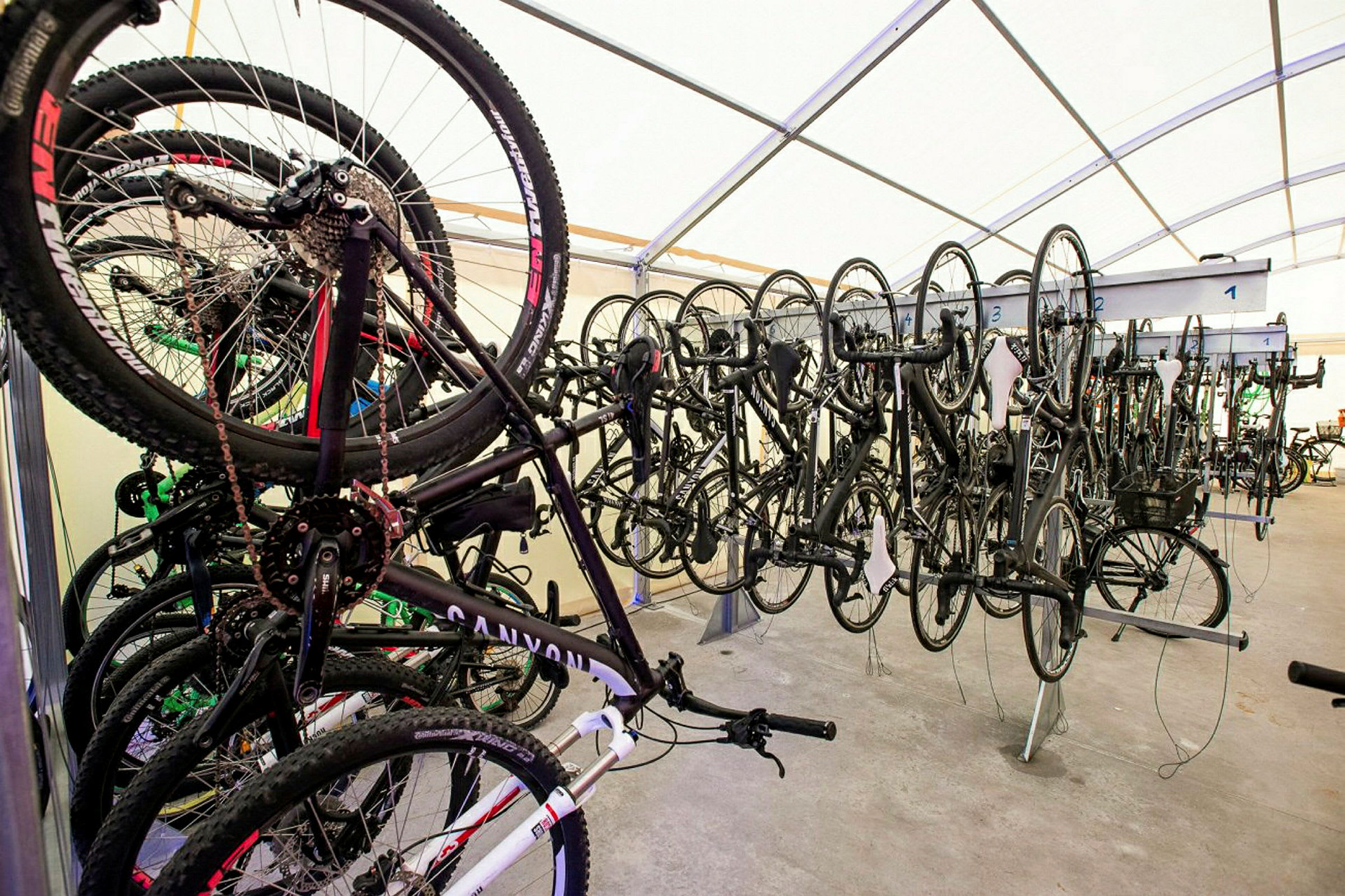 Cyklar förvaras hängande i rad inomhus. (AI-genererad text)