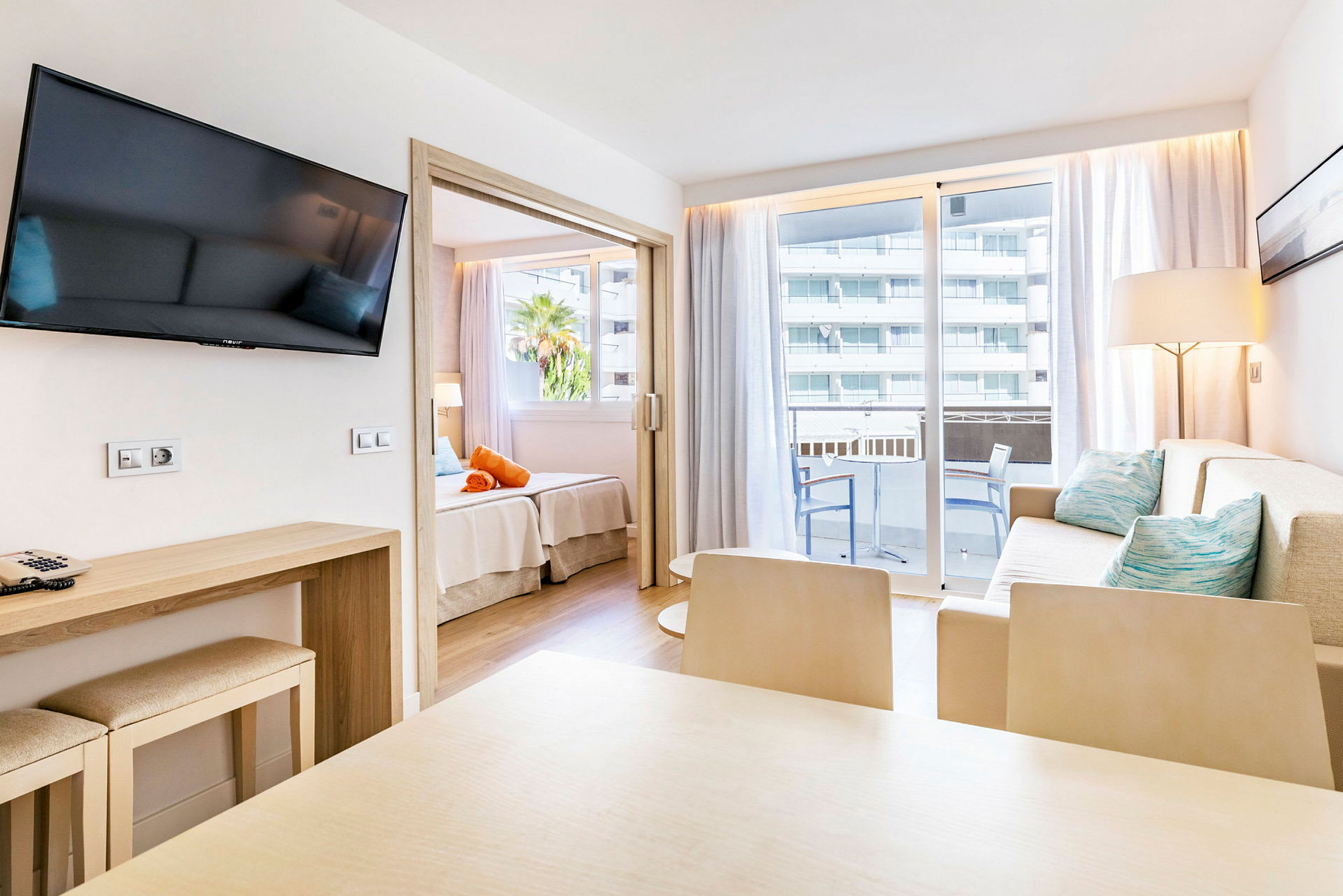 Modernt hotellrum med sittgrupp, matbord, balkong och sovdel. (AI-genererad text)